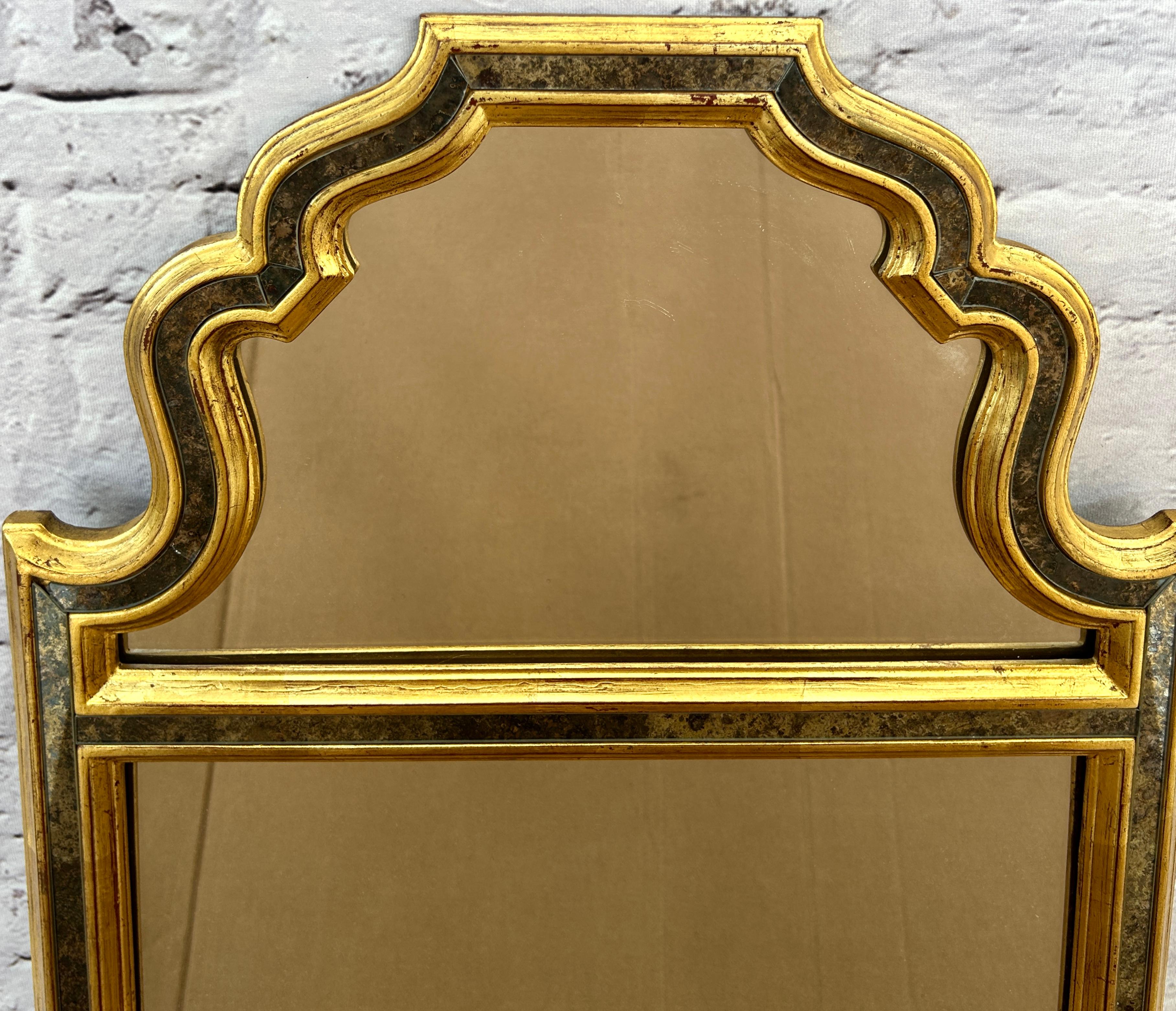 Espejo decorativo de pared de mediados de siglo La Barge de estilo morisco. Sorprendente espejo caracterizado por su intrincado diseño y elegante artesanía. Presenta un marco de arco de color dorado inspirado en el arte y la arquitectura islámicos.