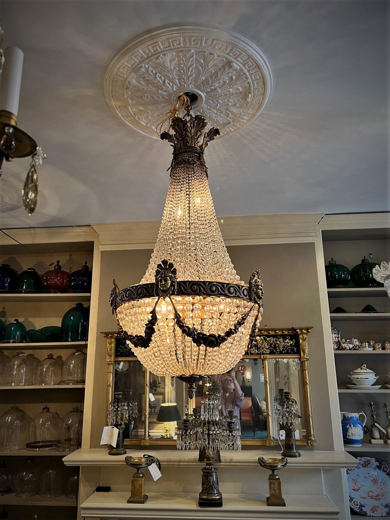 This stunning tent & cascade chandelier, which recently arrived from France, probably originally hung in a public building or a mansion. The bronze and patinated bronze fittings were hand cast and are typical of Belle Époque motifs including rose