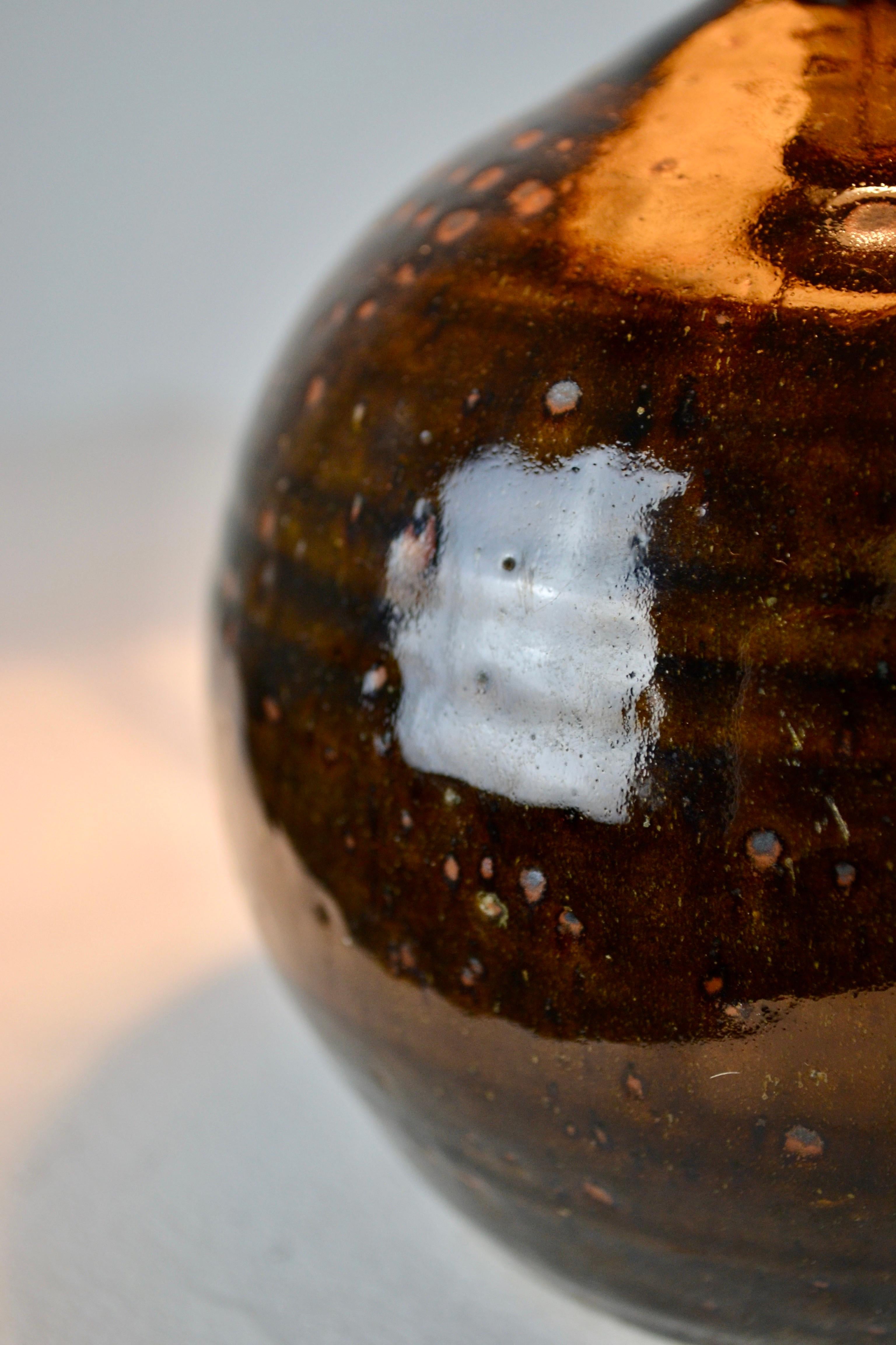 Une superbe lampe vintage des années 1970 signée par Guy Baudat, célèbre céramiste français de La Byne. Pièce unique en grès piqué de pyrite avec des inclusions naturelles, ce qui lui donne un aspect brut et authentique. Son abat-jour original en