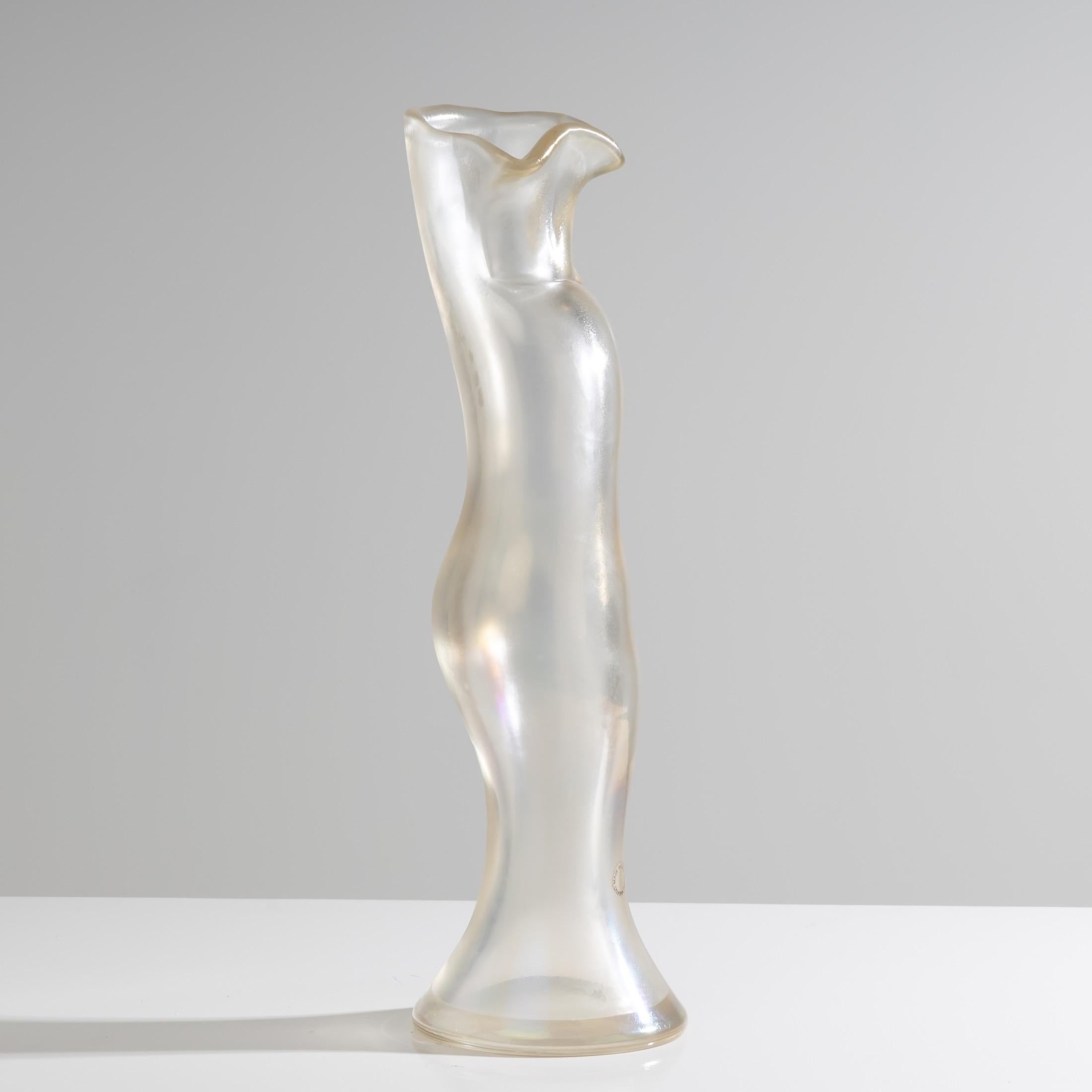 The body of the vase in transparent iridescent glass on the entire exterior.
Of female form, recurring in the work of the artist, this vase is part of the last series of objects designed by Fulvio Bianconi for Venini.
Signed and dated with the