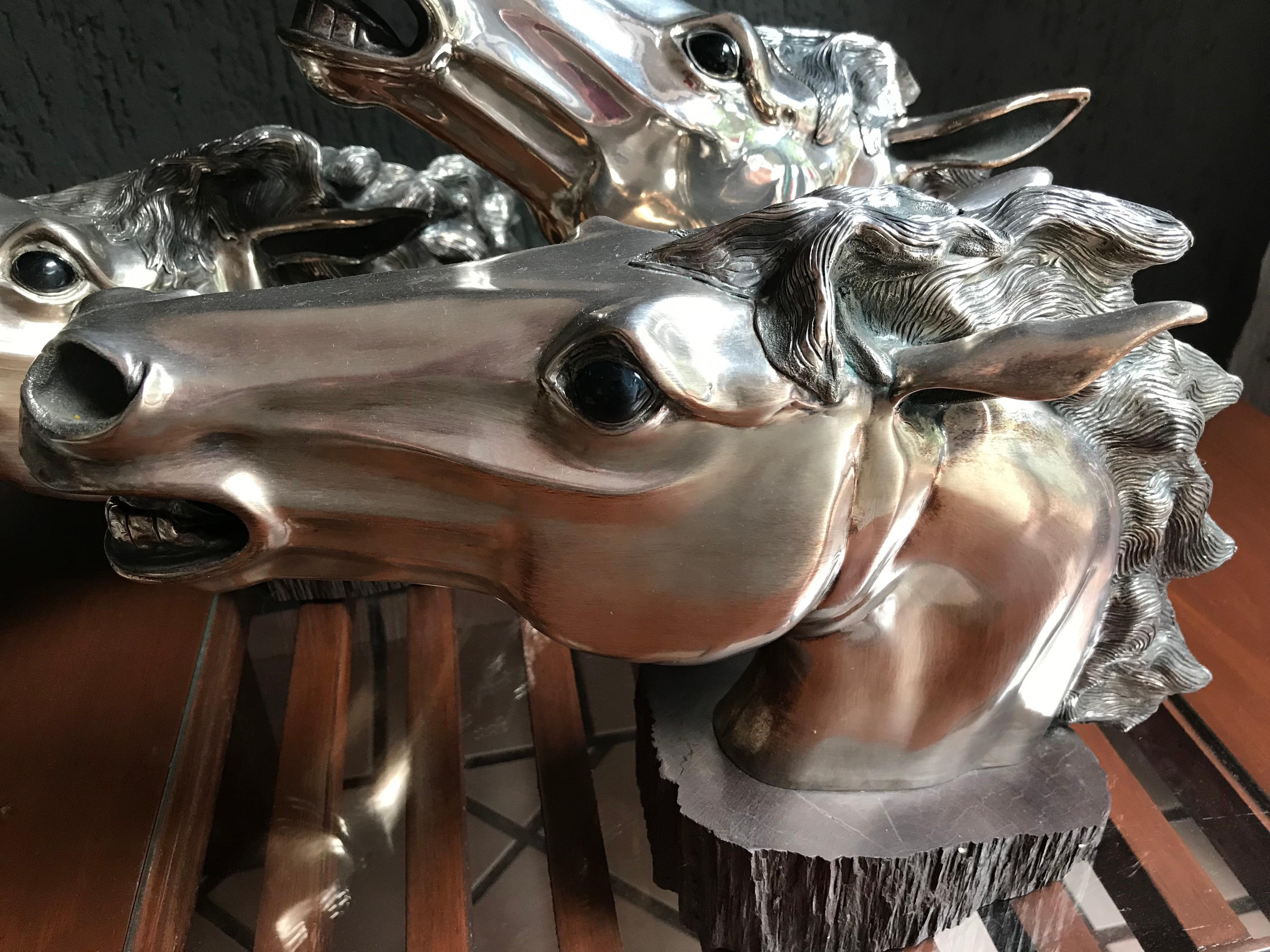 3 heads of horses separately, on a wooden base rosewood, with eyes of onyx. Embossed technique. 2 of the horses have matte finish and the other maintains its original brightness.
