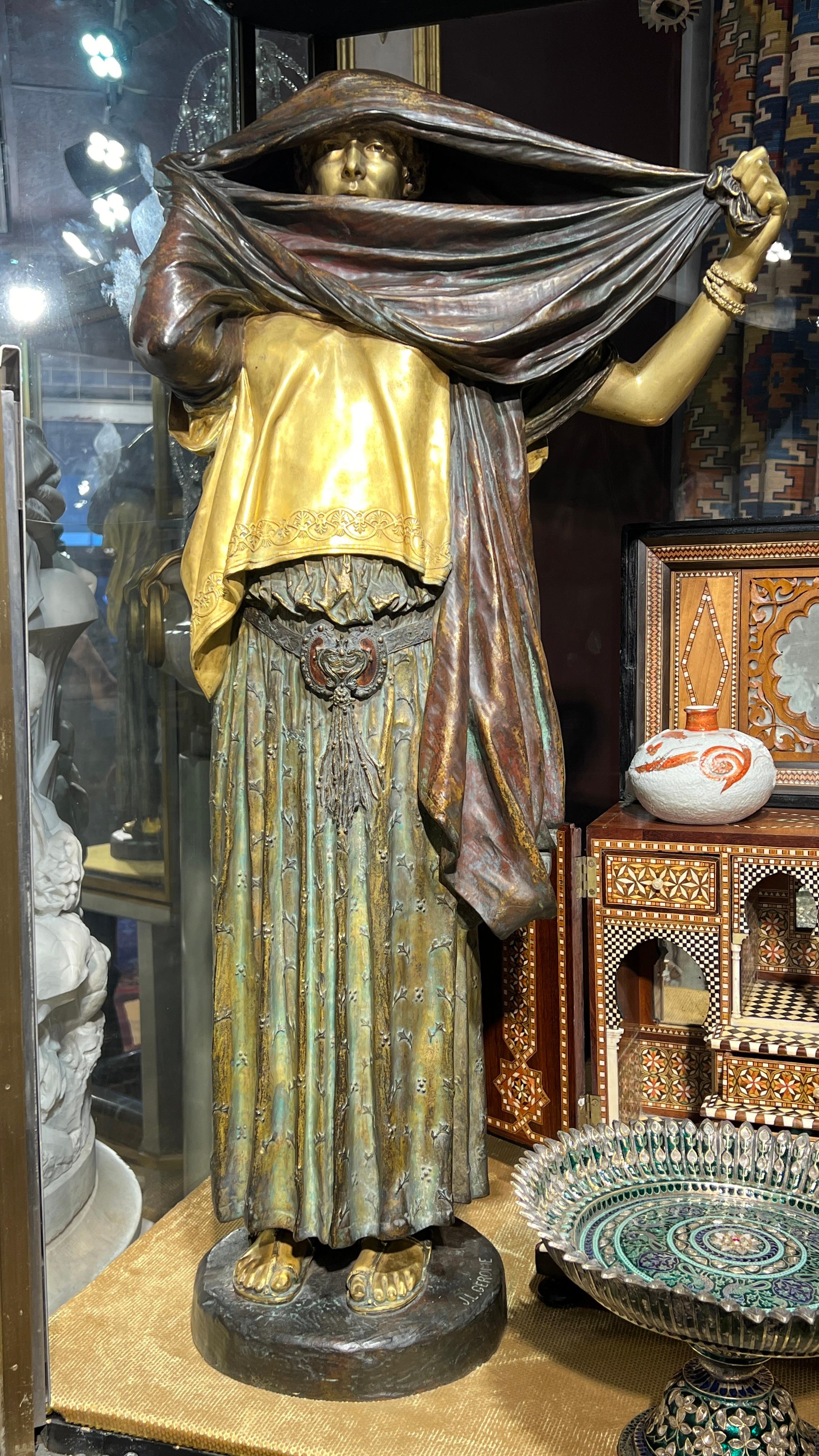 Unsere Bronzestatue La Femme au Voile (Frau mit Schleier) wurde von Siot-Decauville aus Paris nach dem Originalmodell von Jean Leon Gerome (1824-1904) gegossen.  Mit einer Höhe von 85,7 cm (33 3/4 Zoll), feiner Patina und teilweise vergoldeten