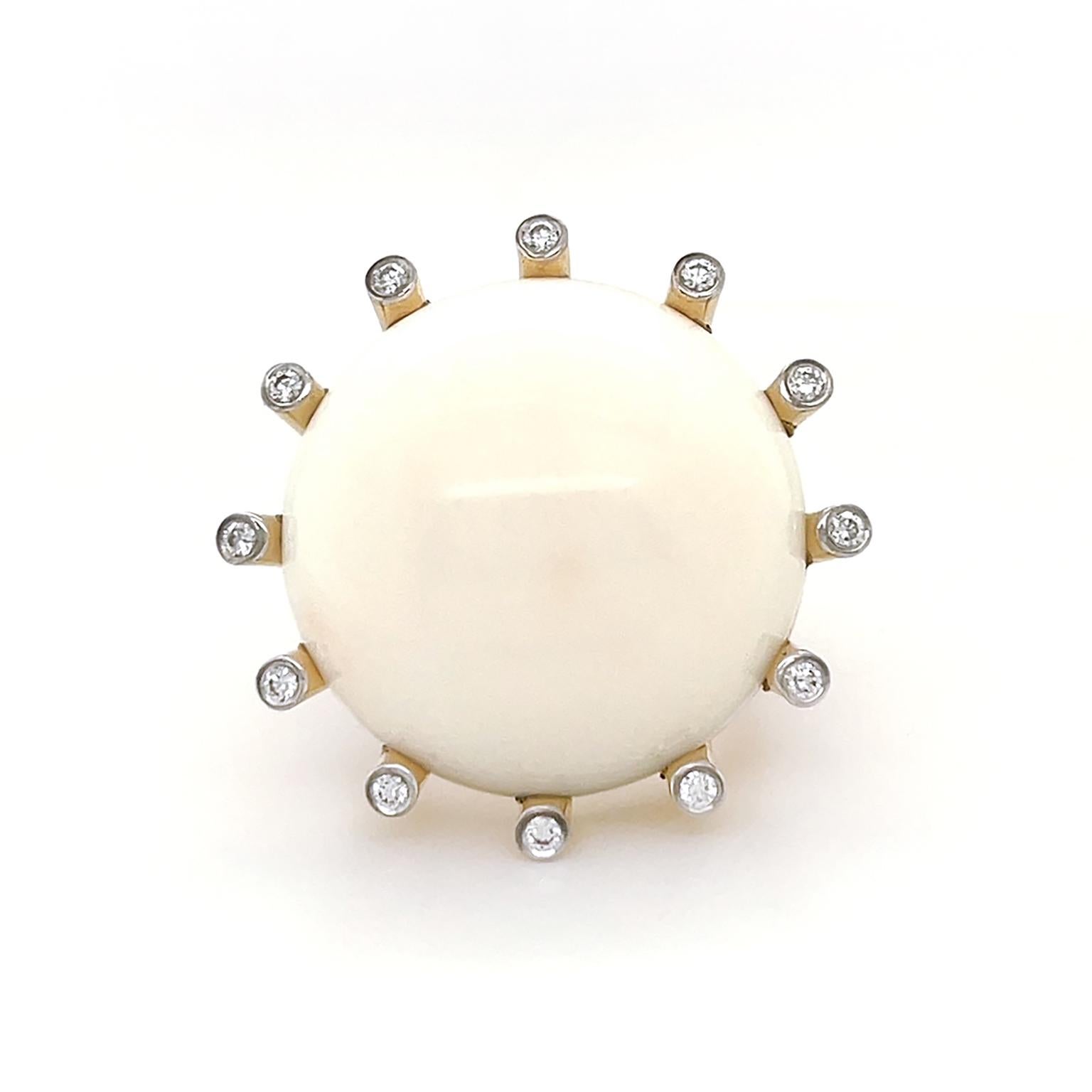 A lustrous white coral embodies the warmth of 18k yellow gold and diamonds for this La Luna ring. Secured by narrow cylinders of 18k yellow gold, the ring features a round 25mm carving of white coral with a single brilliant cut diamond on each tip.