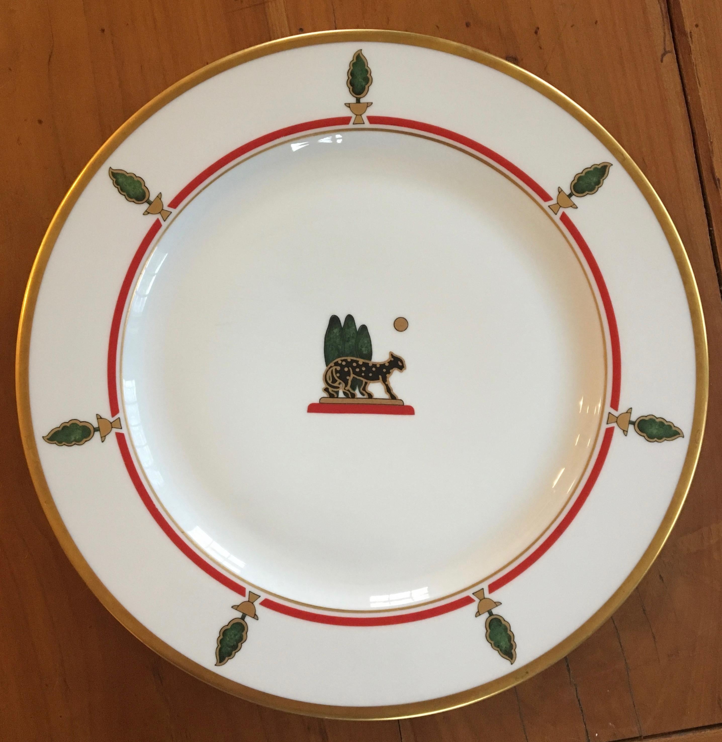 Cartier tabletop. A Cartier Limoges collaboration from the 1980s.
Featuring gold rim and detail, the classic Cartier black panther, red inner band, green topiaries, trees, animalia. Set includes 8 large charger/service plates. Made in France. All