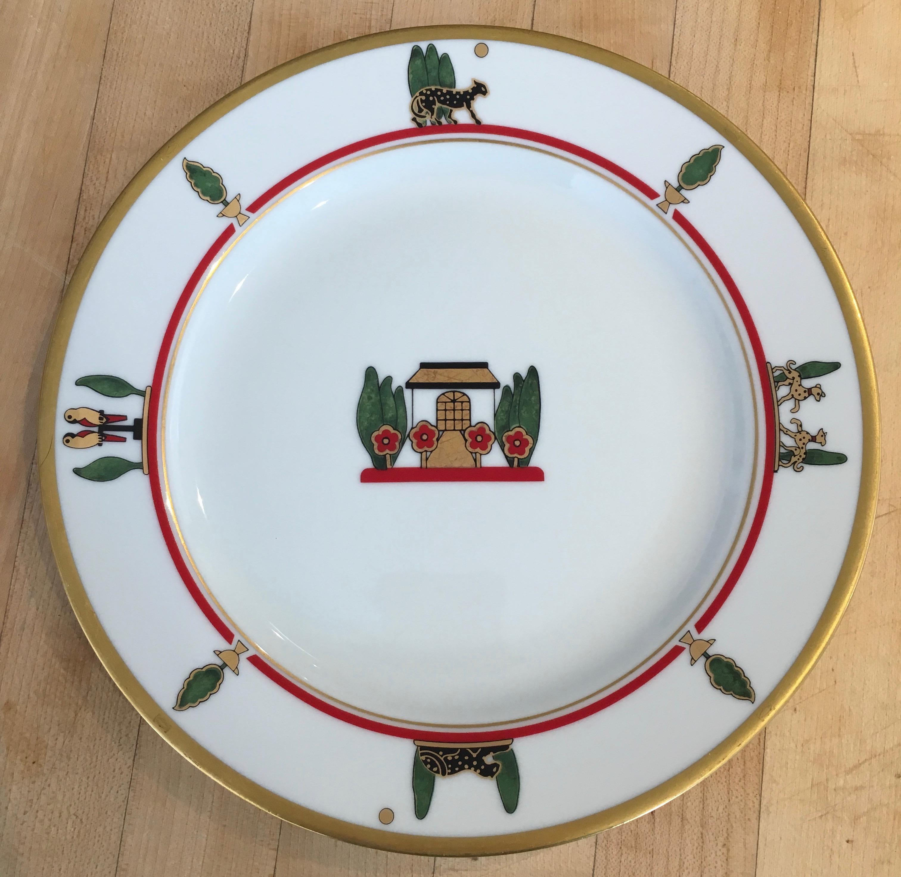 Cartier salad or dessert plates. Featuring gold rim and detail, the iconic Cartier black panther, red inner band and green topiaries, animalia; 1980s Cartier and Limoges France collaboration.
 