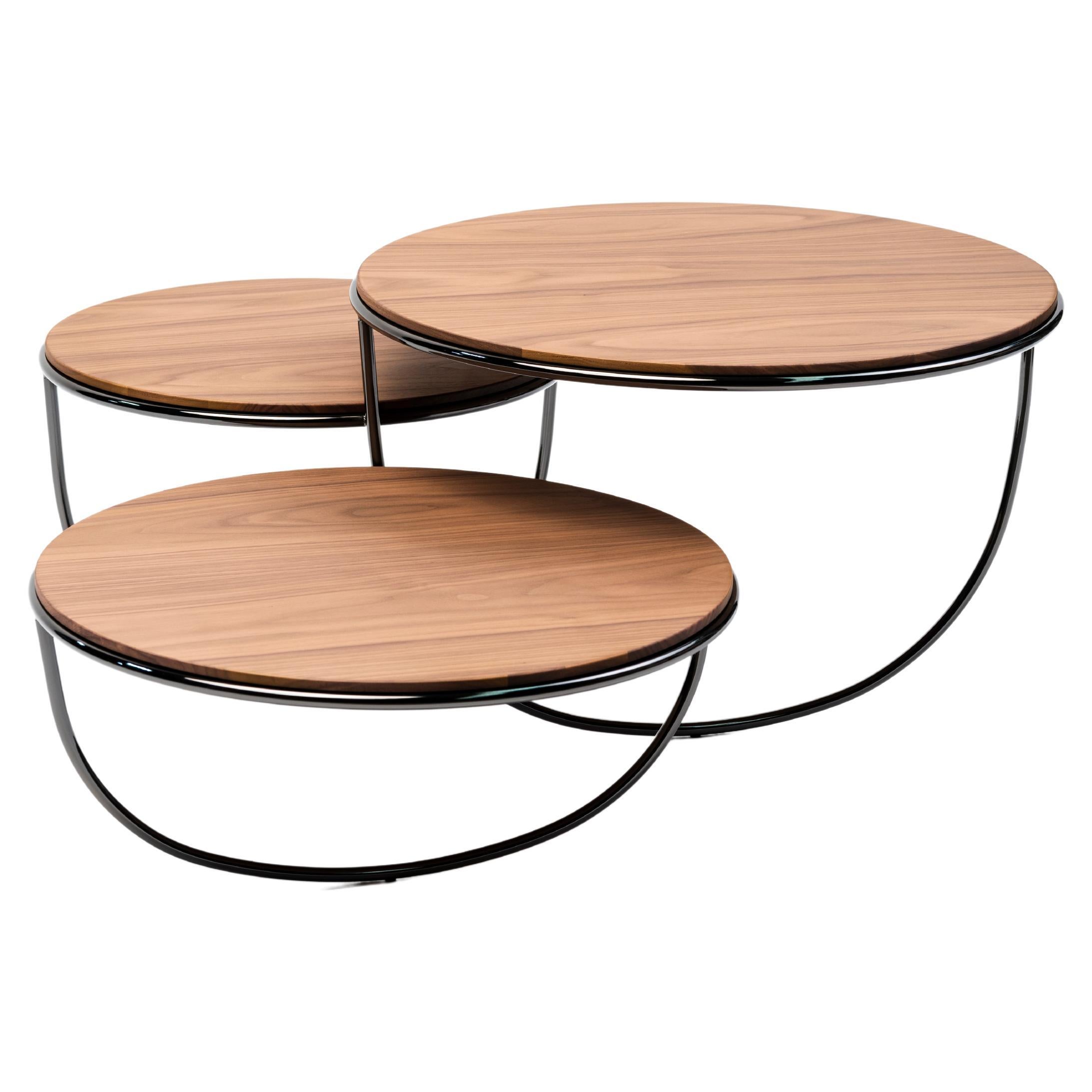 At first sight, Trio is a side table that consists of three transparent bowls overlapping one another.
The opening of each bowl is covered with either a glass, metal or wood top. The shape of the bowl is suggested by a single curved line —