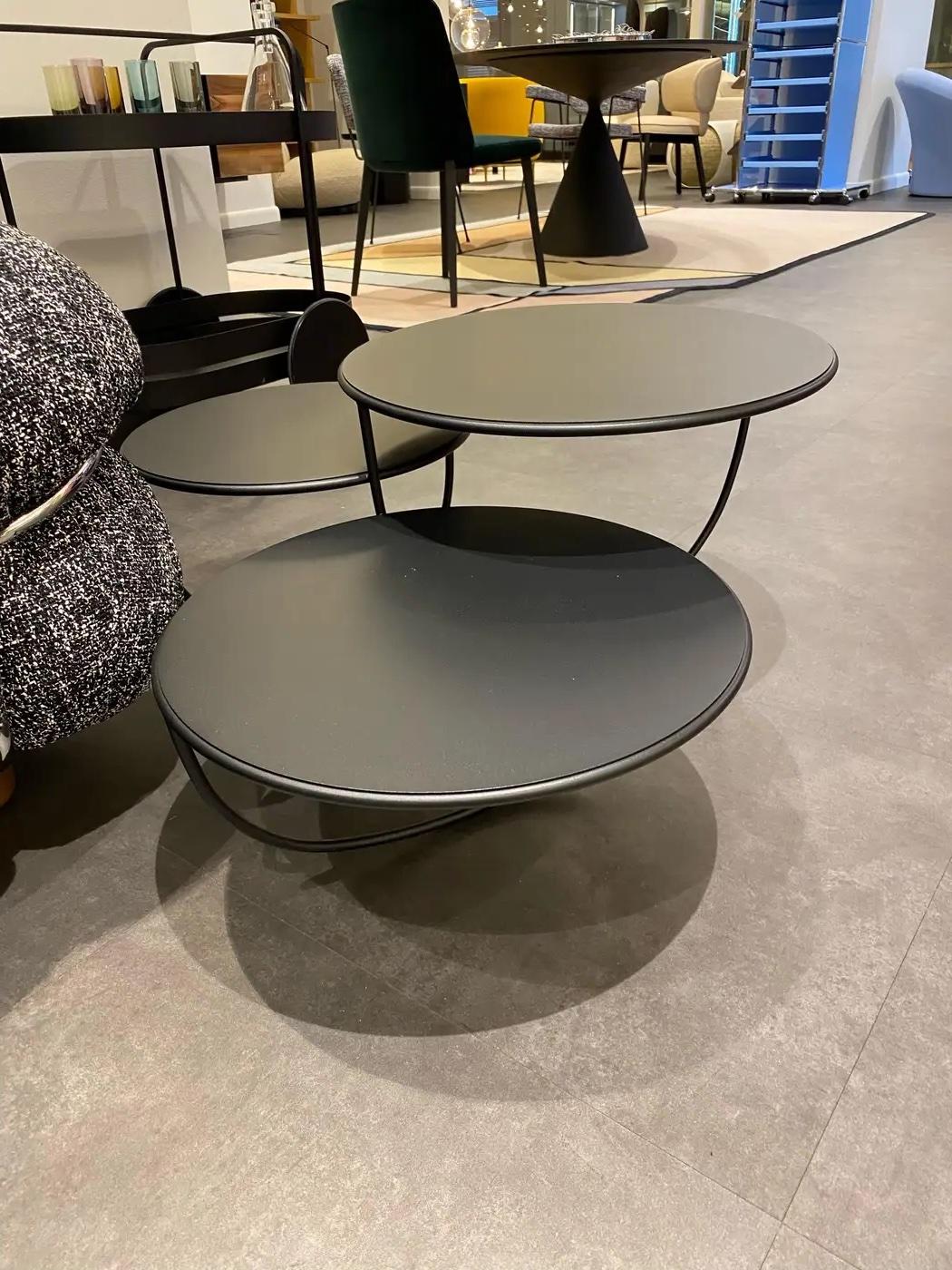 At first sight, Trio is a side table that consists of three transparent bowls overlapping one another. The opening of each bowl is covered with either a glass, metal or wood top. The shape of the bowl is suggested by a single curved line — seemingly