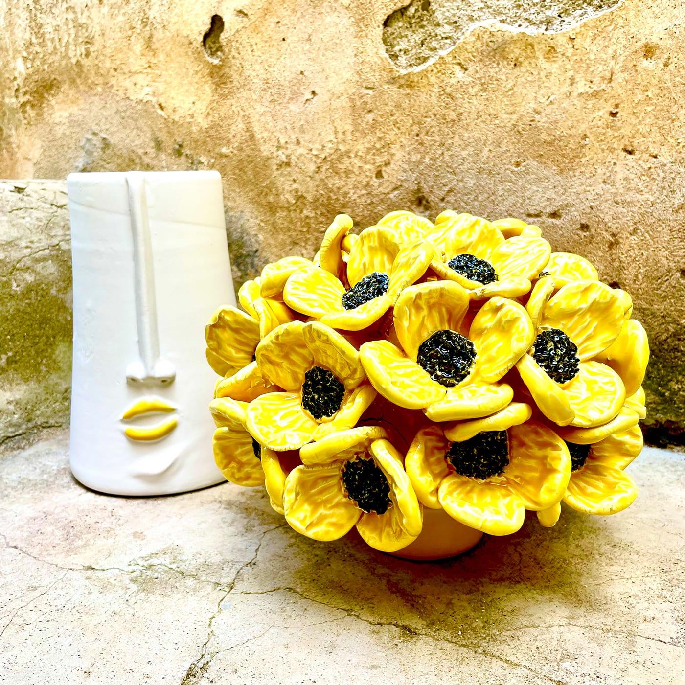 An authentic work of art sporting playful anthropomorphic traits, this ceramic design is a romantic synthesis of decorative and storage potential. Equipped with an inner unit to easily collect items, it boasts a bouquet of blossoming yellow daisies