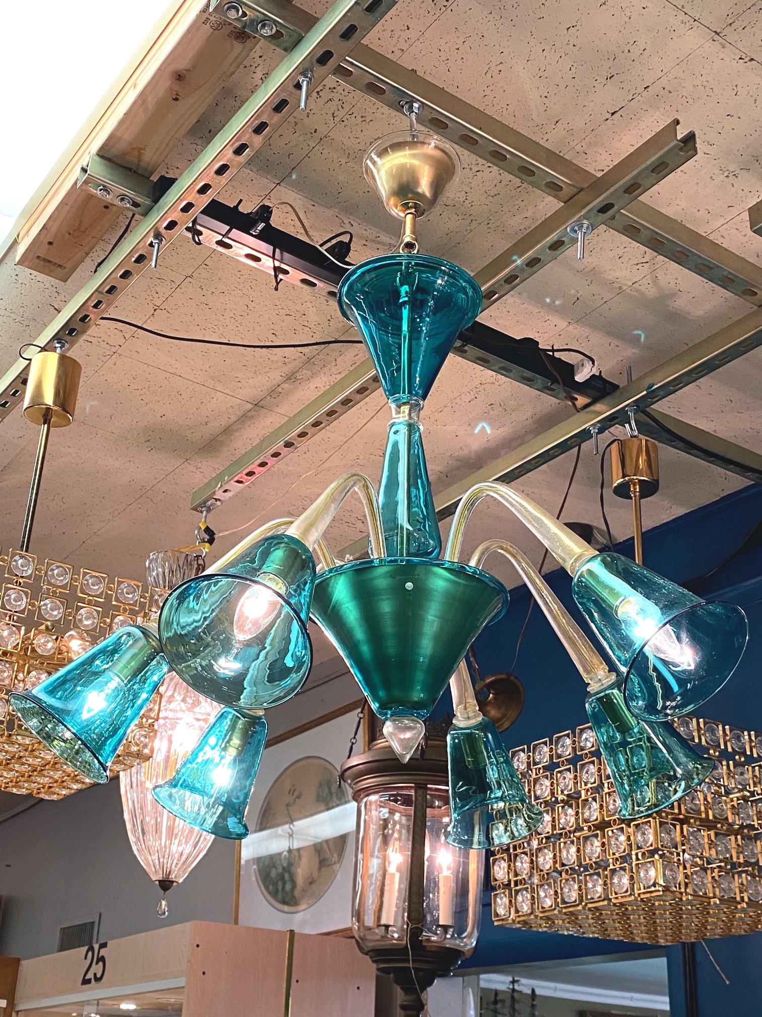 Le lustre soufflé à la main La Murrina des années 1980 en aventurine claire et sarcelle est une pièce remarquable caractérisée par ses éléments de couleur sarcelle vibrante. En outre, les bras transparents et les pièces d'accentuation sont en verre