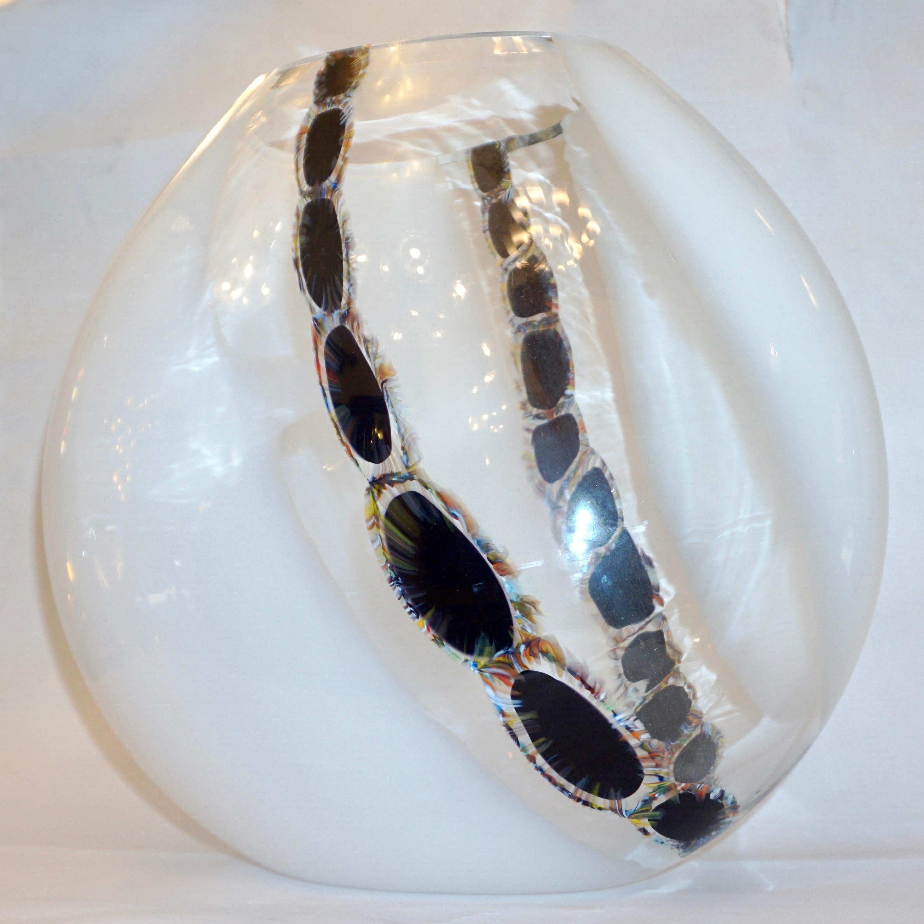 Italian very decorative modern design vase of organic oval shape in Venetian sommerso Murano glass, Work of Art blown with large panels of snow white glass captured inside the outer crystal clear layer, decorated inside with jewel-like black murrine