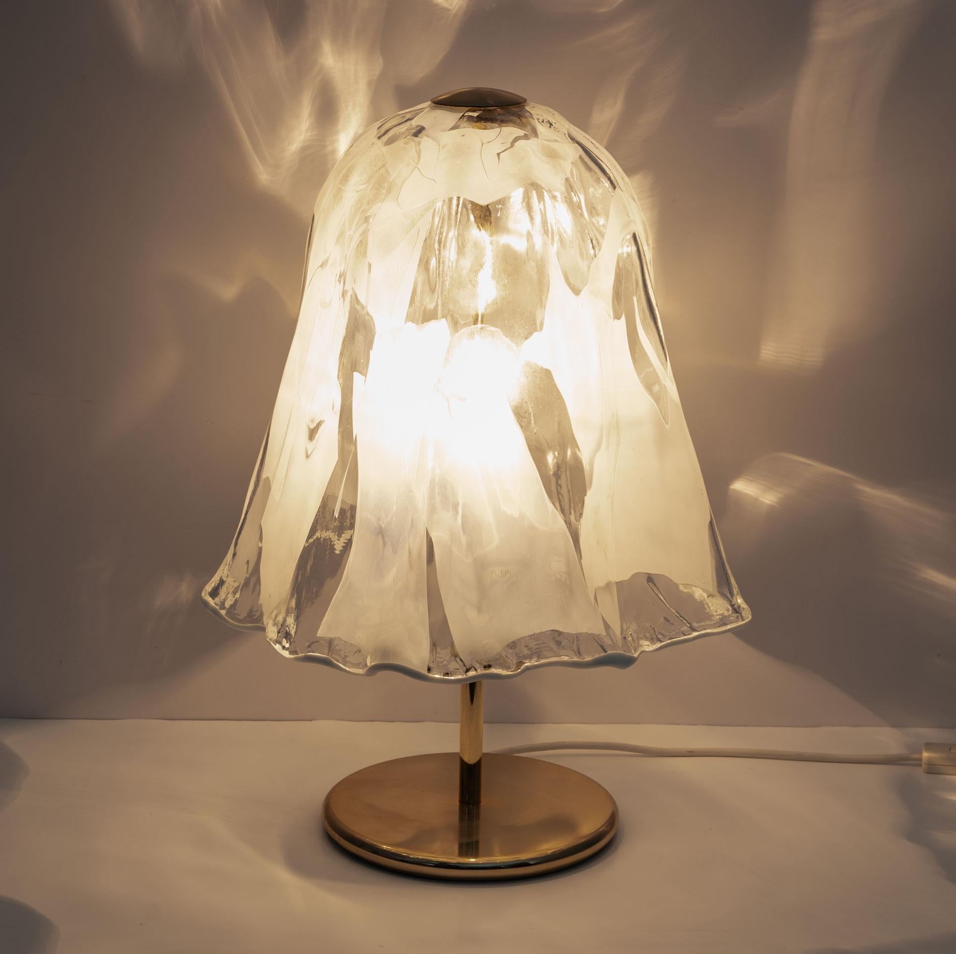 Table lamp by the renowned La Murrina, made in the artistic period of the 70s. The shade of this light gracefully resembles a bell-shaped flower. It's so sweet.

This lamp not only illuminates but also proudly displays true Murano craftsmanship. The