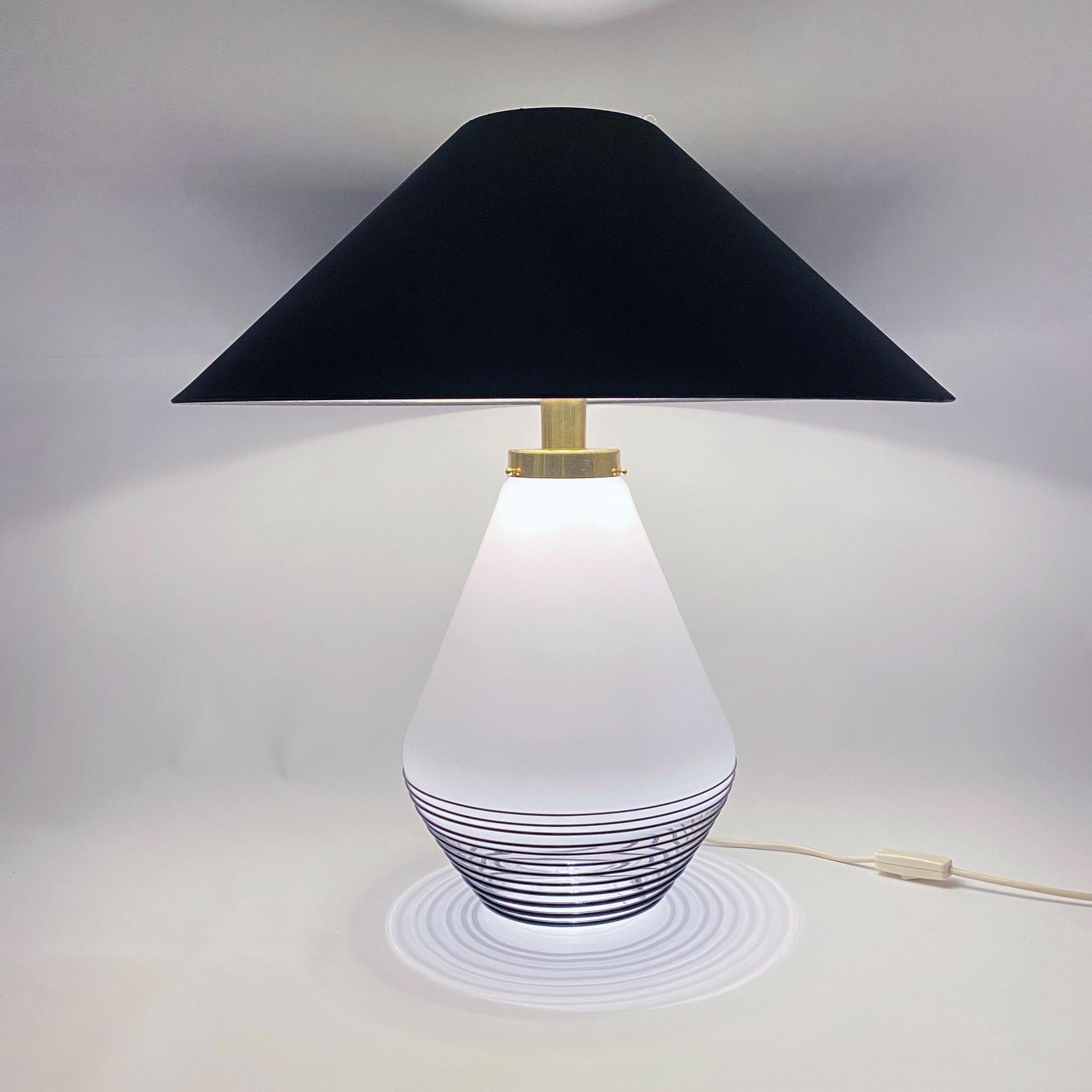 Rare and stunning Lino Tagliapietra attributed Murano glass table lamp by La Murrina. The base consists of a milky white glass lamp with a black swirl design and has a brass neck. The neck has two bulbs: one that shines upward toward the shade and