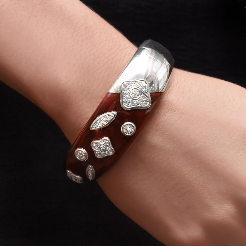 Dieses prächtige Armband wurde von dem weltbekannten italienischen Unternehmen La Nouvelle Bague entworfen. Sie sind bekannt für ihre exquisiten Emaillearbeiten, die das Klassische mit dem Modernen verbinden.
Dieses breite Armband besteht zu drei