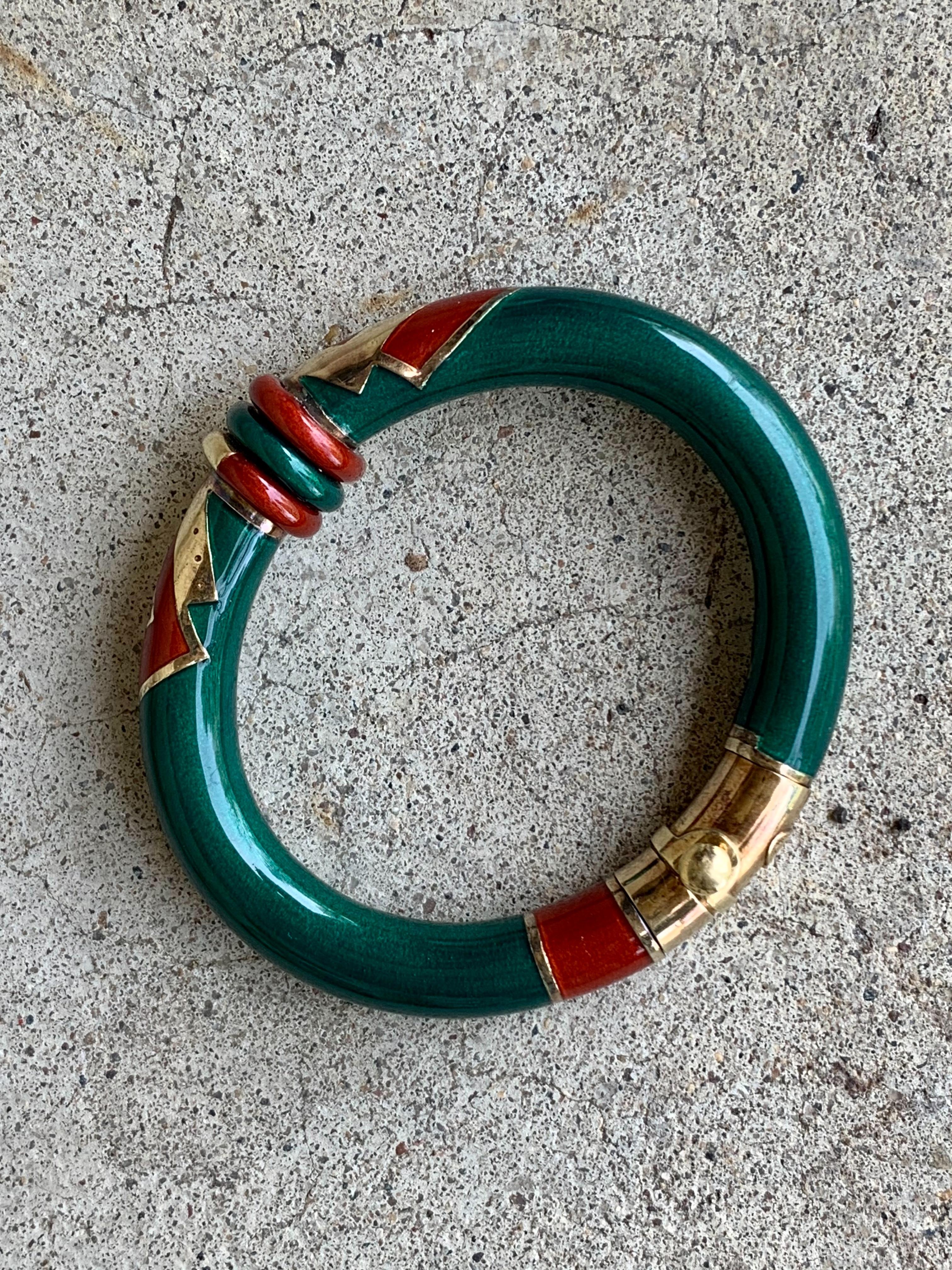 This fabulous La Nouvelle Bague Enamel hinged bangle bracelet features green, orange and Gold enamel geometric designs.  The bangle is accented 18 karat yellow Gold and Sterling Silver. 

Stamped: 