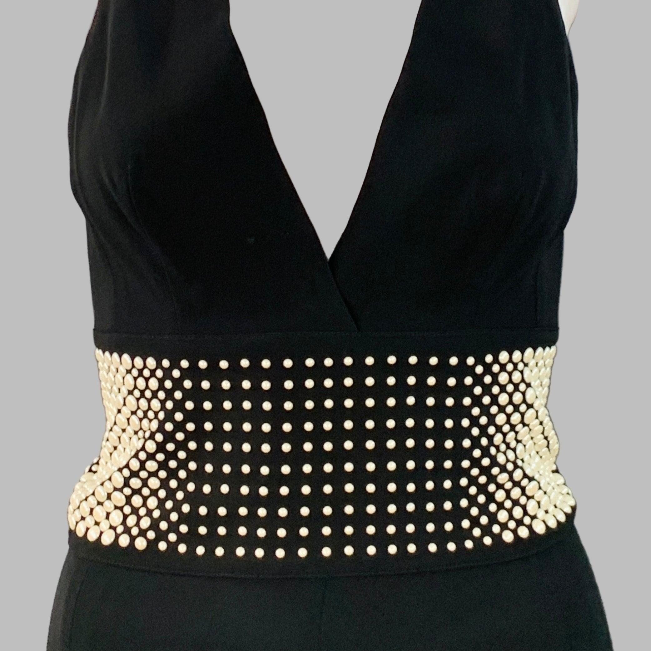 LA PERLA-Overall
aus schwarzem Viskose-Stretch-Mischgewebe mit tiefem V-Ausschnitt, weißer Kunstperlen-Verzierung an der Taille und Reißverschluss am Rücken. Hergestellt in Italien, guter gebrauchter Zustand. Mehrere kleine Spuren und