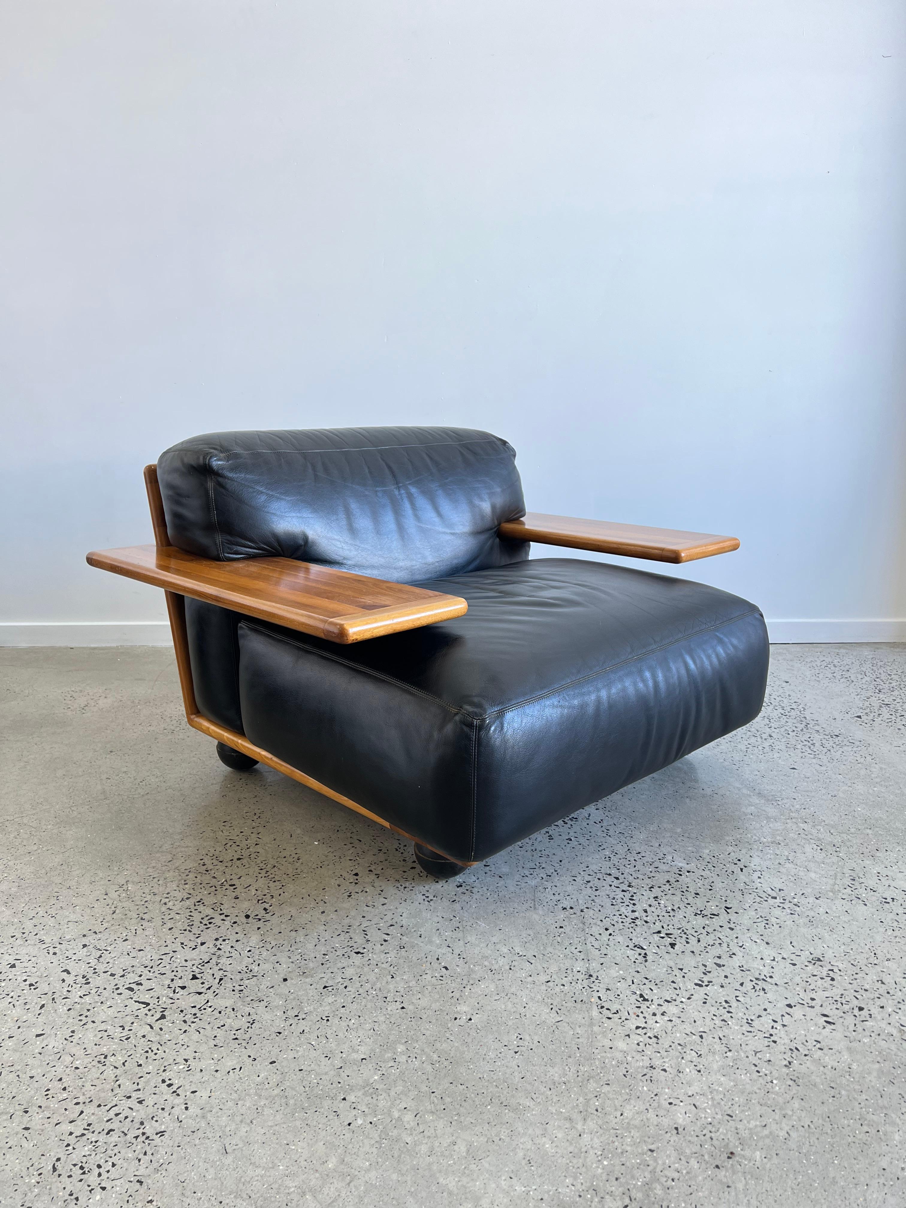 Fantastic low lounge chairs designed by Mario Bellini and manufactured by Cassina, Italy 1971. This chair is from the Pianura series and has a solid walnut wooden frame. The cushions are made of black leather. The legs are made of black