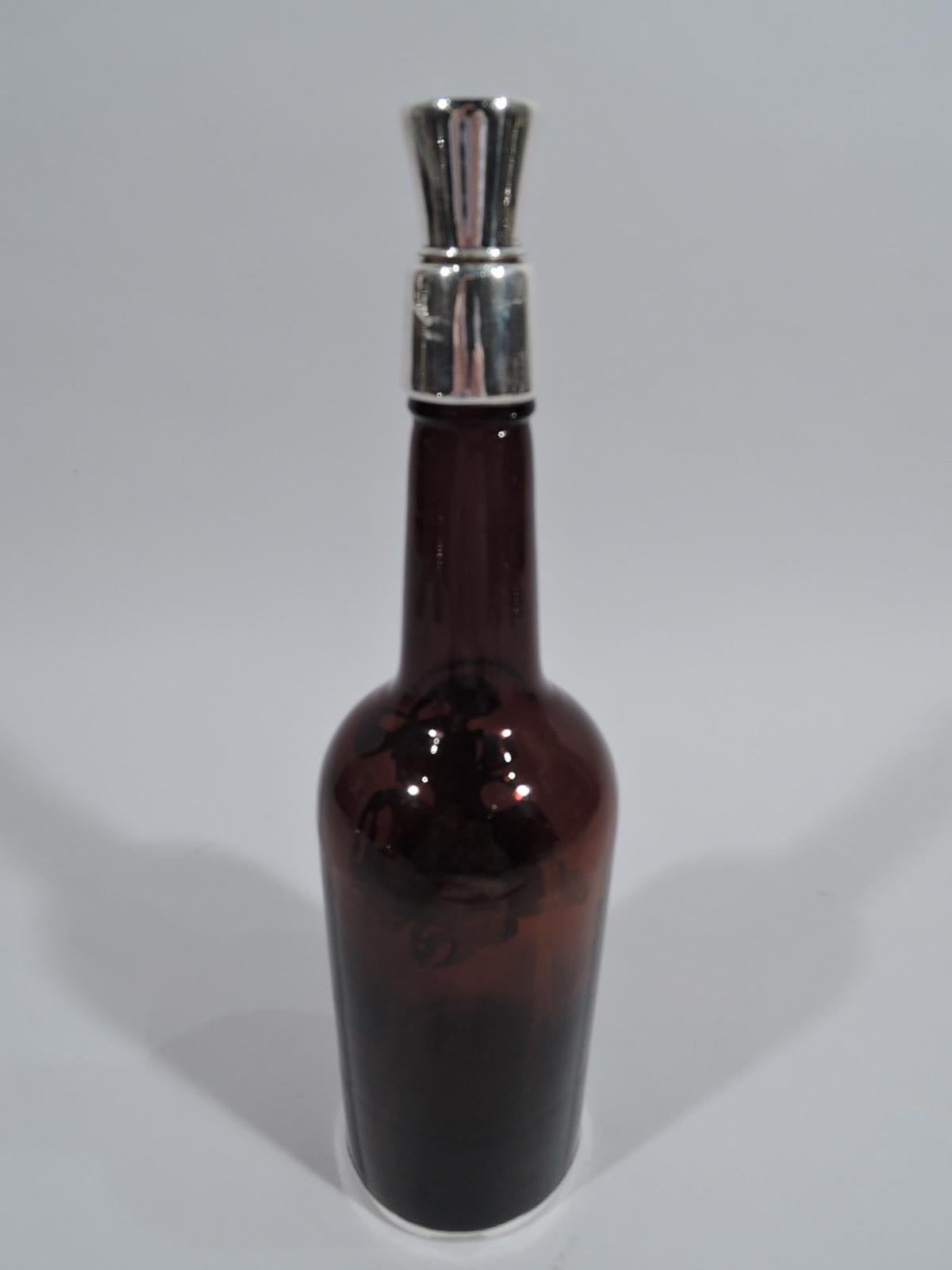 Edwardian glass decanter with engraved silver overlay, ca 1910. Bottle with straight sides, curved shoulder, and upward tapering cylindrical neck. Sterling silver rim collar and stopper with cork plug. On decanter front is pictorial overlay in form