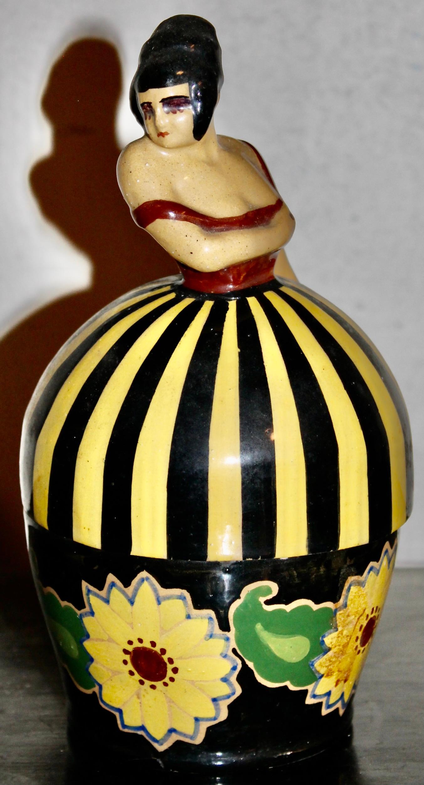 Two part ircular figural container of a female dancer. Large flowers pictured on the black bottom base.  Deep rich brightly glazed.  Fully signed on the bottom. 