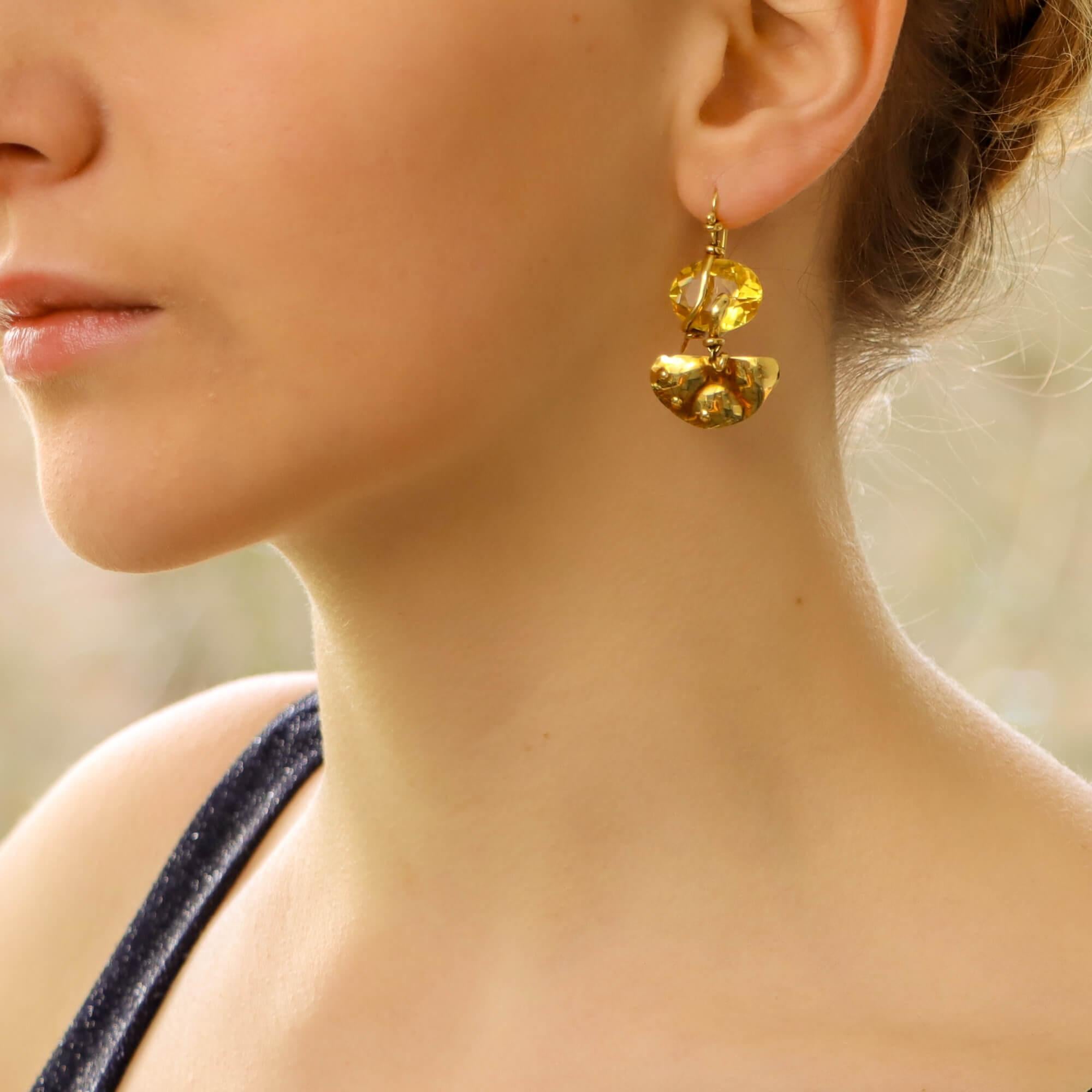 A beautiful pair of naturalistic citrine snake earrings set in 18k yellow gold. 

Each earring is prominently set with an oval cut citrine which is wrapped within a snake's tail made of gold. The snake detailing is incredibly subtle yet effective