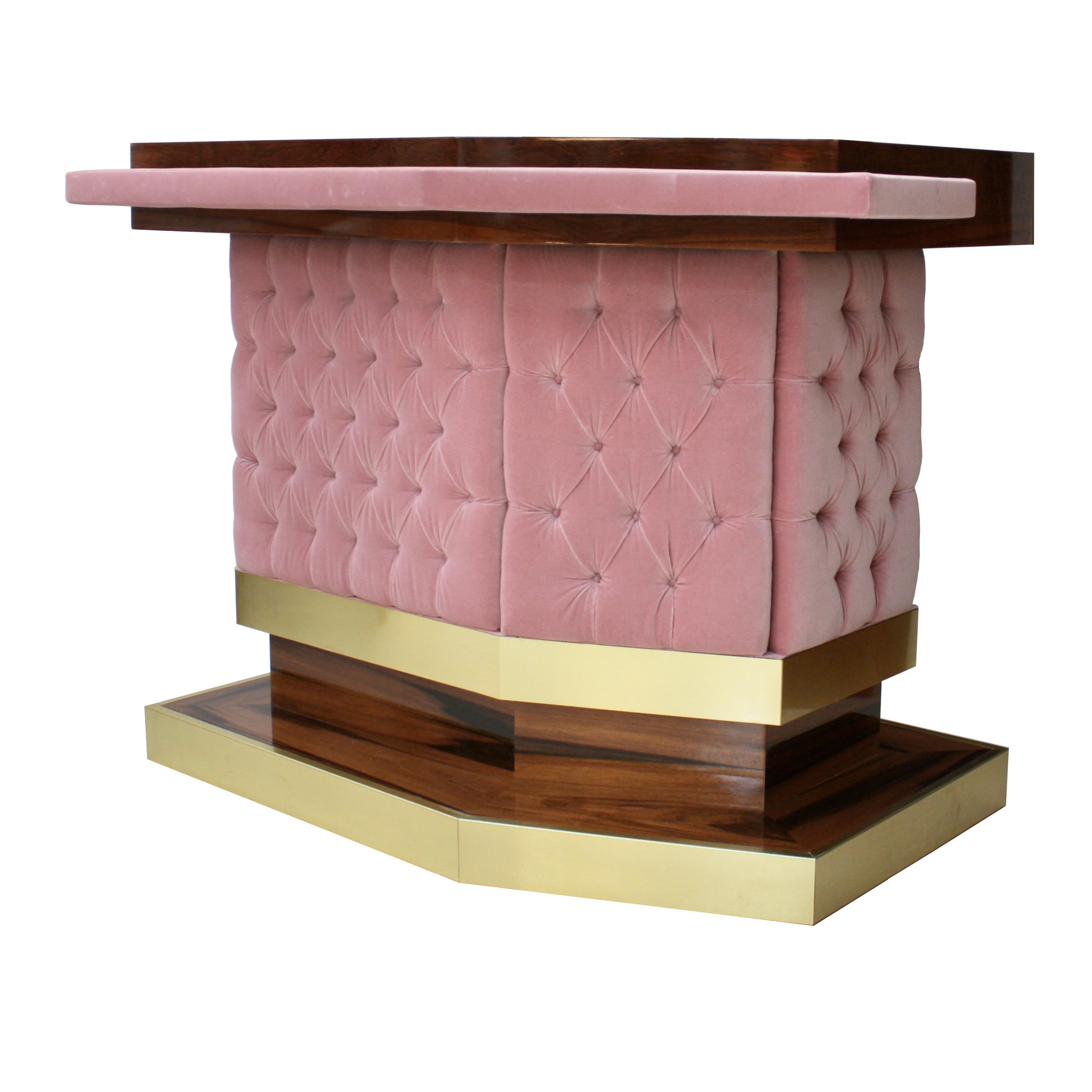 A wonderful mid-century style Bar counter designed by L.A. Studio Interiorismo, made of solid wood covered with high gloss wood veneer in L-shape, front surface upholstered in baby pink cotton velvet capitoné and brass details.