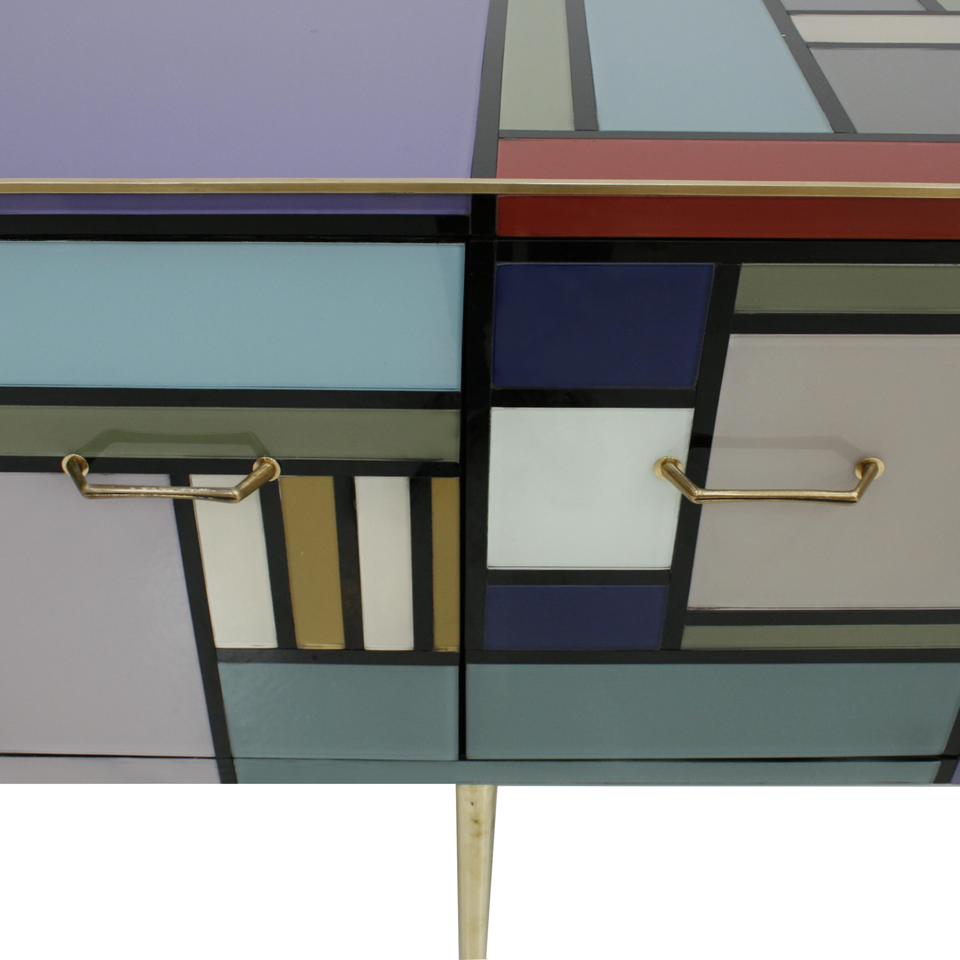 Italian sideboard with four doors and six legs, with wooden structure covered in colored glass and profiles, handles and feet in brass. Made in Italy.
