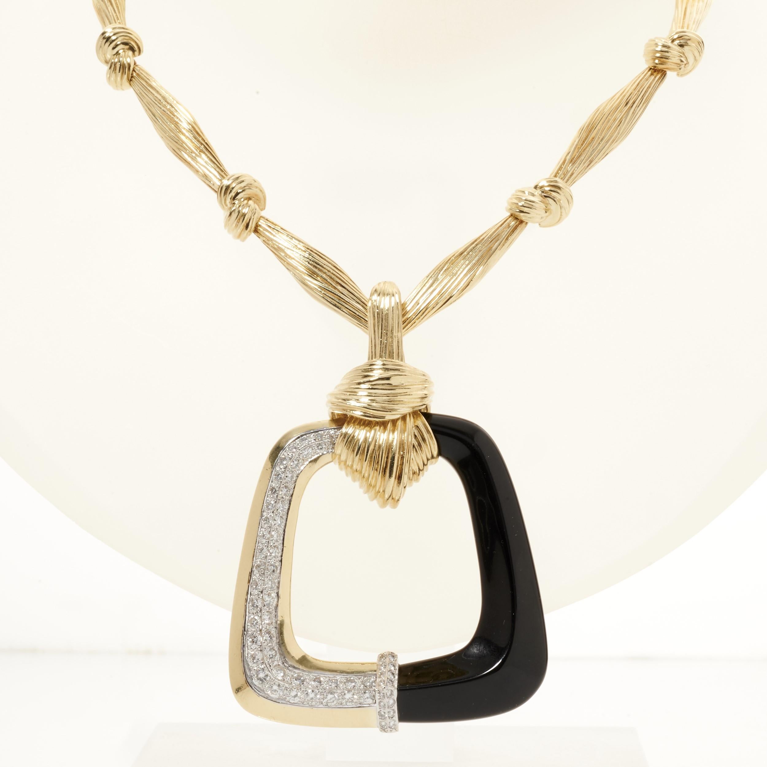 Un superbe collier La Triomphe en or avec un pendentif carré ouvert orné d'onyx noir envoûtant et de diamants éblouissants. 

Le pendentif est composé d'or jaune 18 carats, d'onyx noir et de 62 diamants ronds. Ils pèsent environ 2,50 carats et ont
