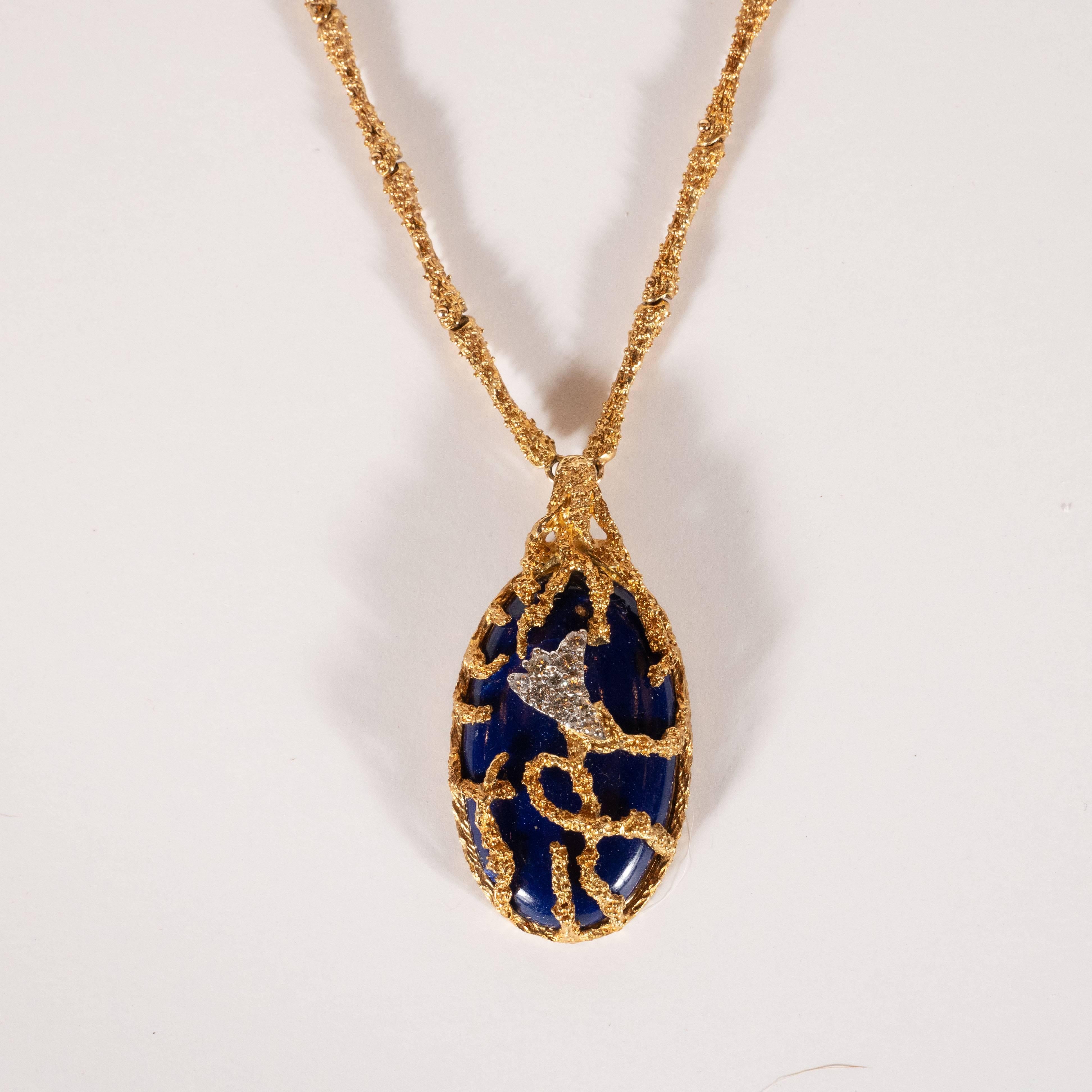 This stunning necklace was hand crafted by the esteemed French jewelry atelier, La Triomphe, circa 1970. It features a teardrop lapis circumscribed by textured 18k yellow gold resembling tendrils of elkhorn coral that ensconce the central stone. A