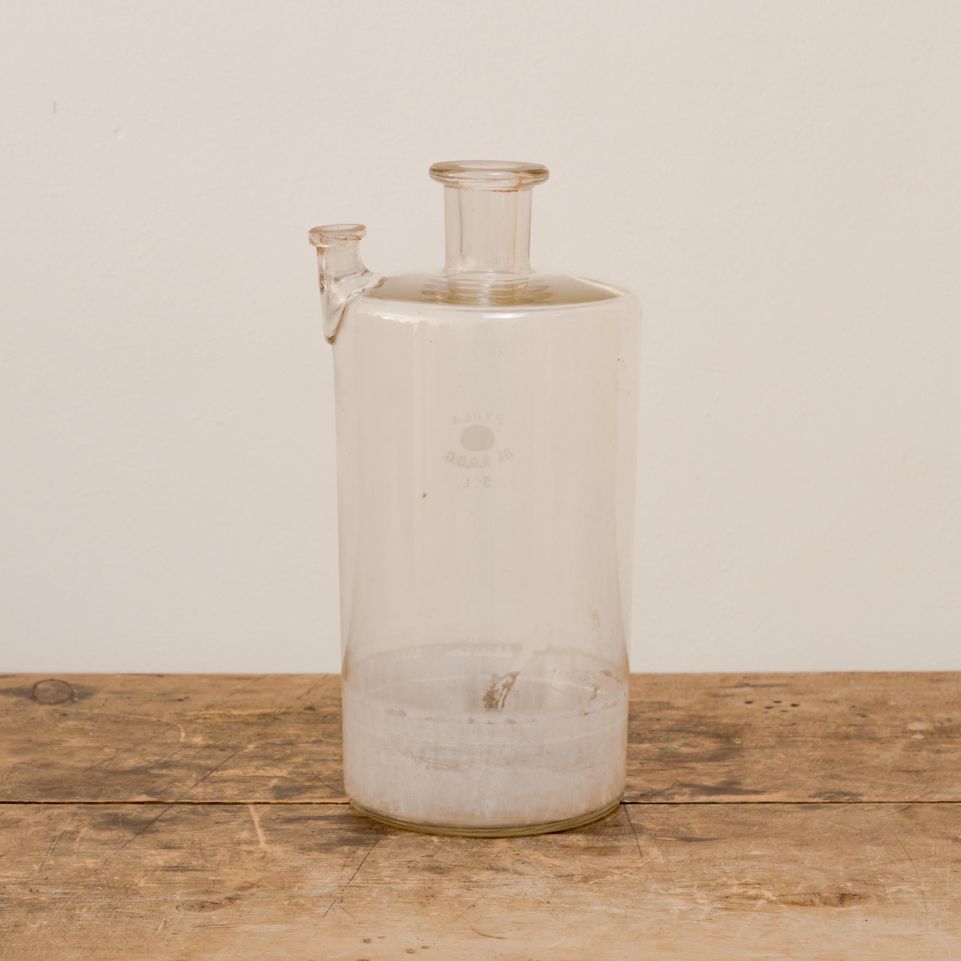Cylindrical lab glass vessel with spout.
