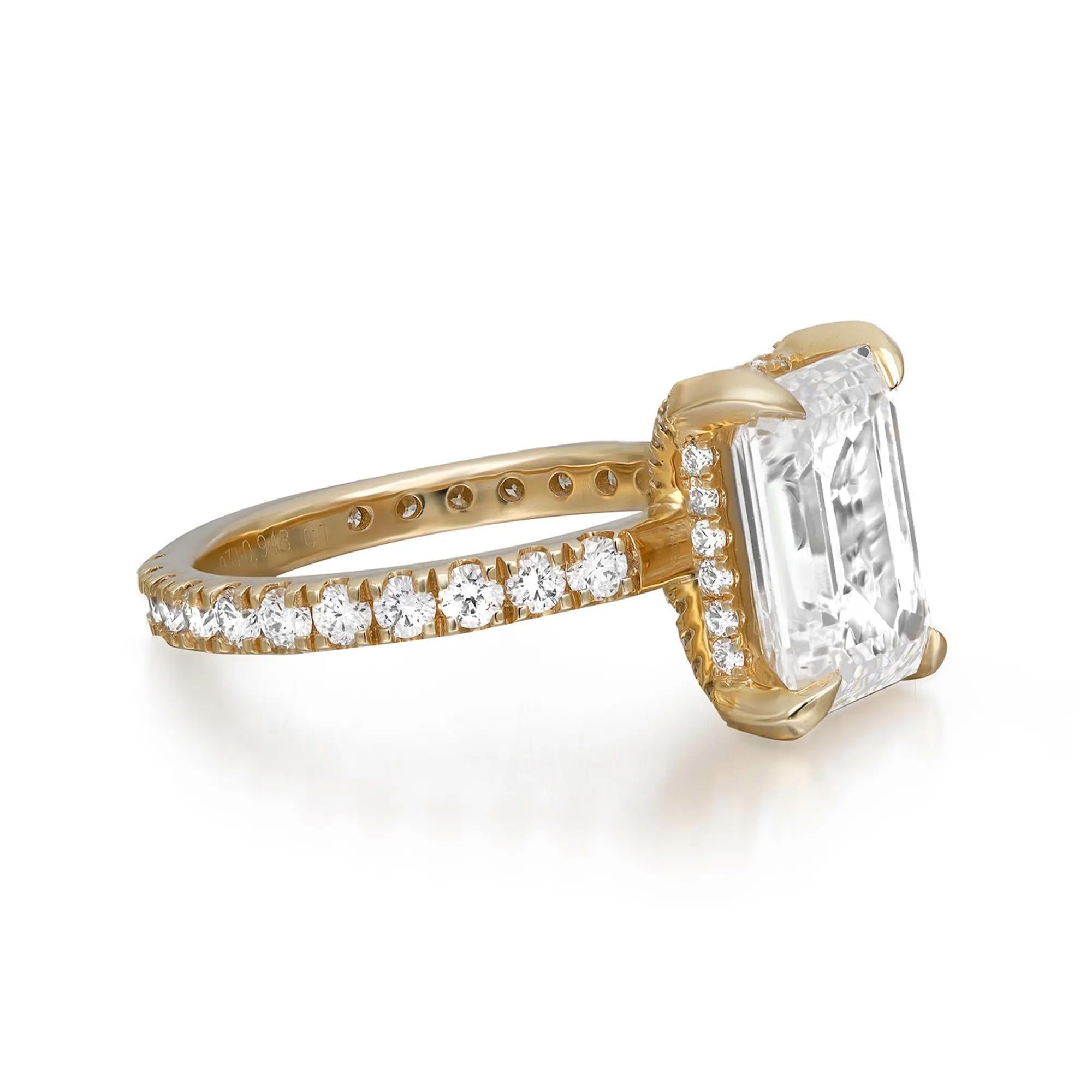 This enchanting ring is adorned with a sparkling GIA certified emerald cut lab grown diamond in the center, secured firmly in a beautiful four prong setting and a classic diamond shank that lends the final touch to the design aesthetic. The total