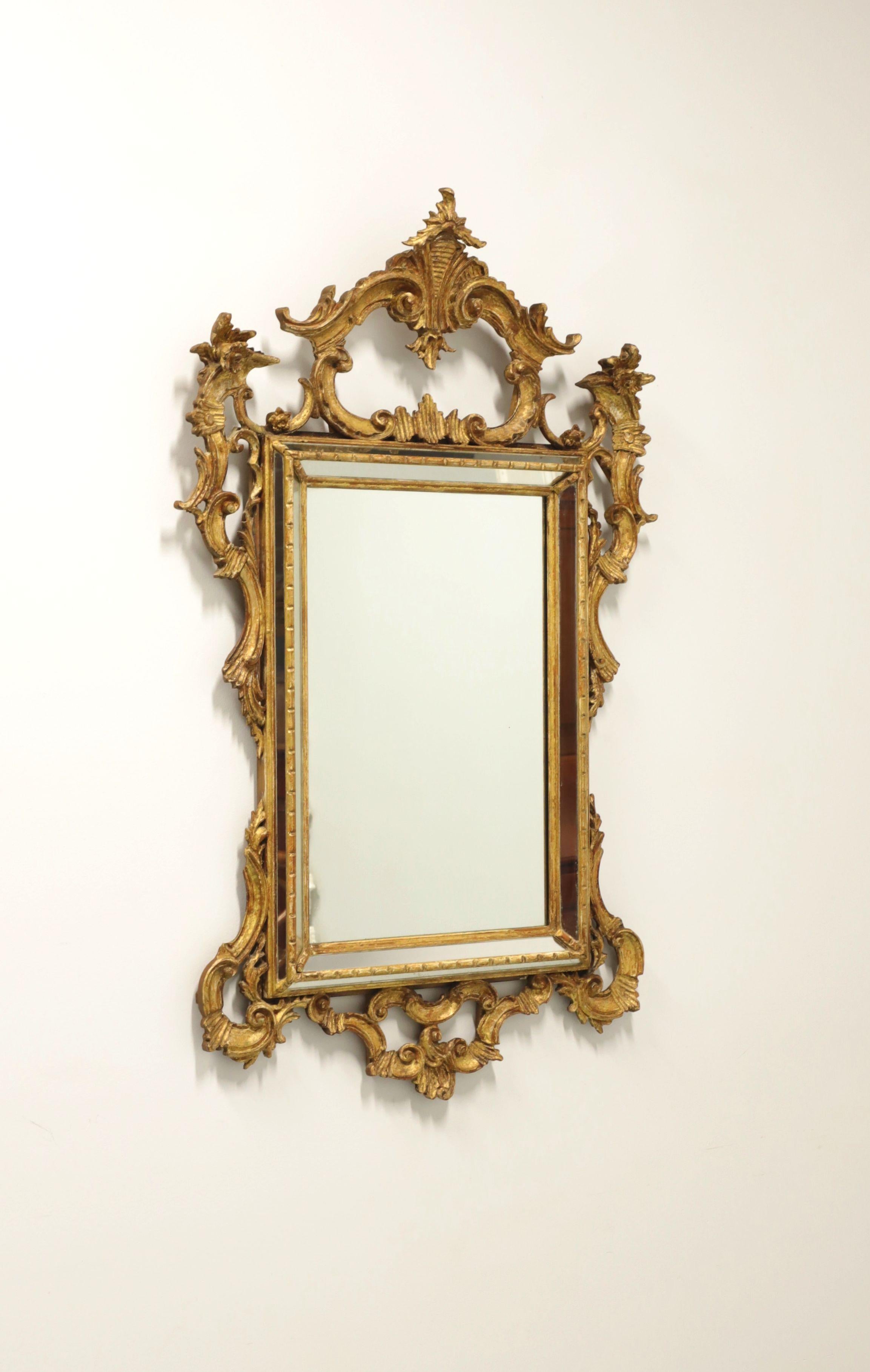A parclose wall mirror in the French Louis XV Rococo style by Labarge. Mirror glass in an intricately carved gold gilt painted wood frame with strips of mirrors surrounding the outer edges. Features crest to top, botanic accents and scrollwork
