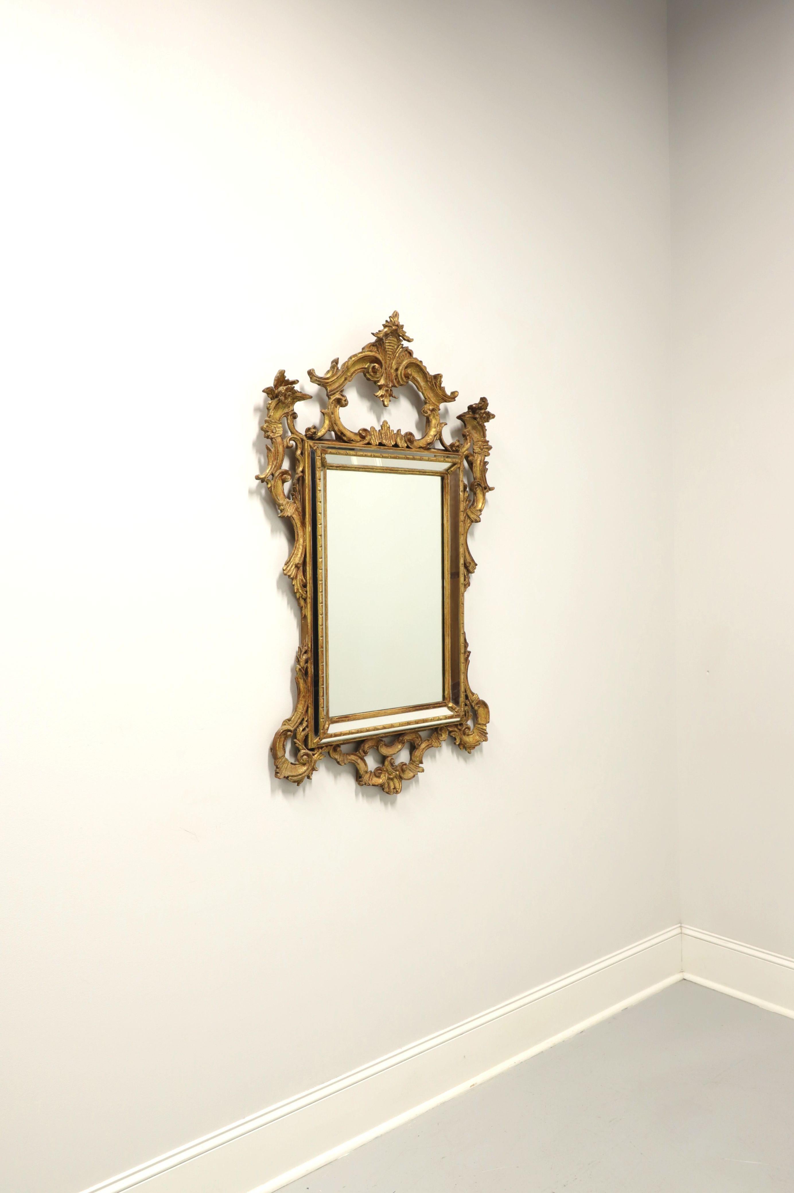 A parclose wall mirror in the French Louis XV Rococo style by Labarge. Mirror glass in an intricately carved gold gilt painted wood frame with strips of mirrors surrounding the outer edges. Features crest to top, botanic accents and scrollwork