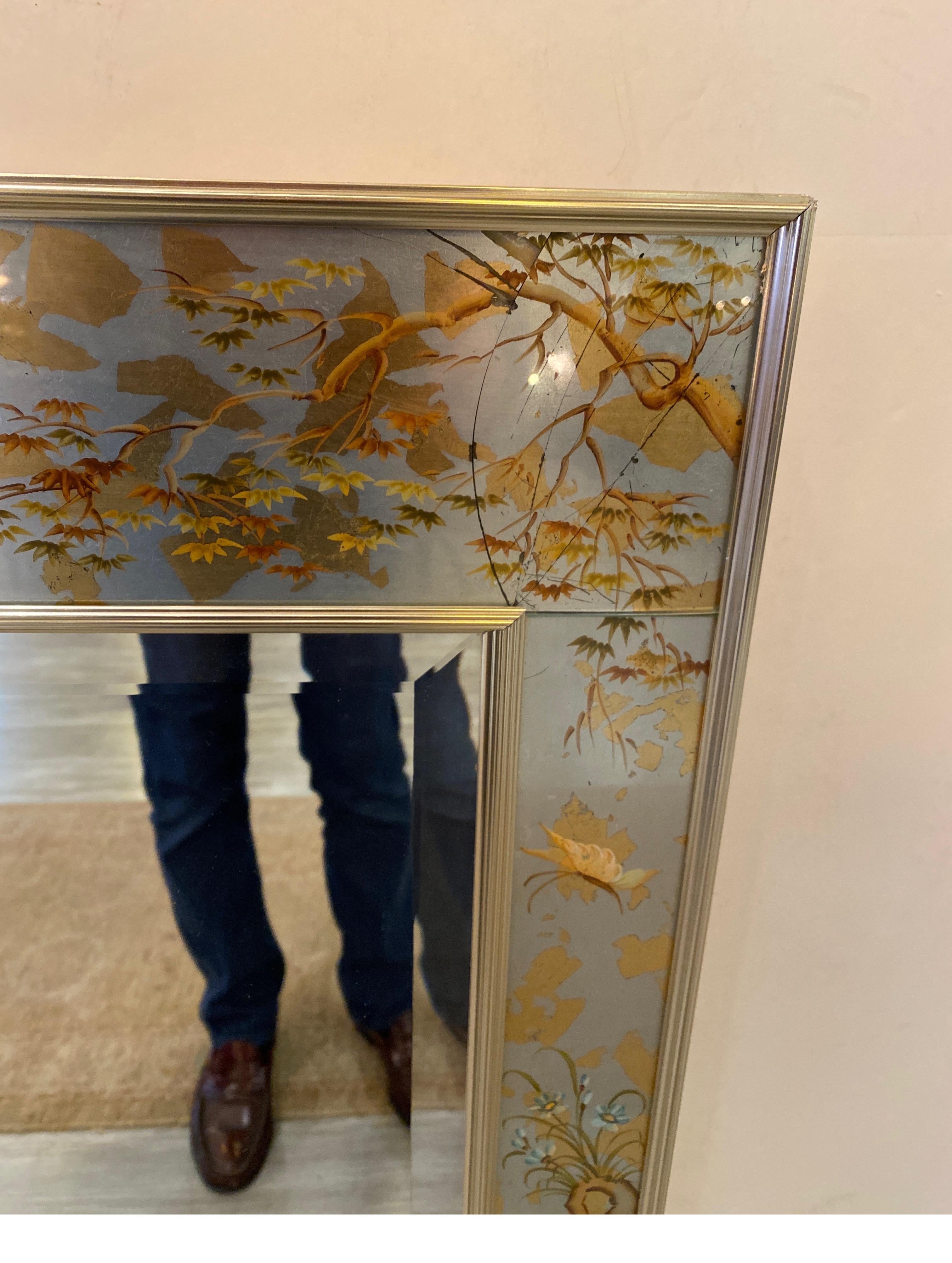 A hand painted reverse painted LaBarge mirror, in a silver and gold eglomise frame with beveled mirror, signed by the artist in the lover corner, dated 1979. Spectacular detail in excellent condition. Nice large size. 
Measure: 42.5 High by 38.5