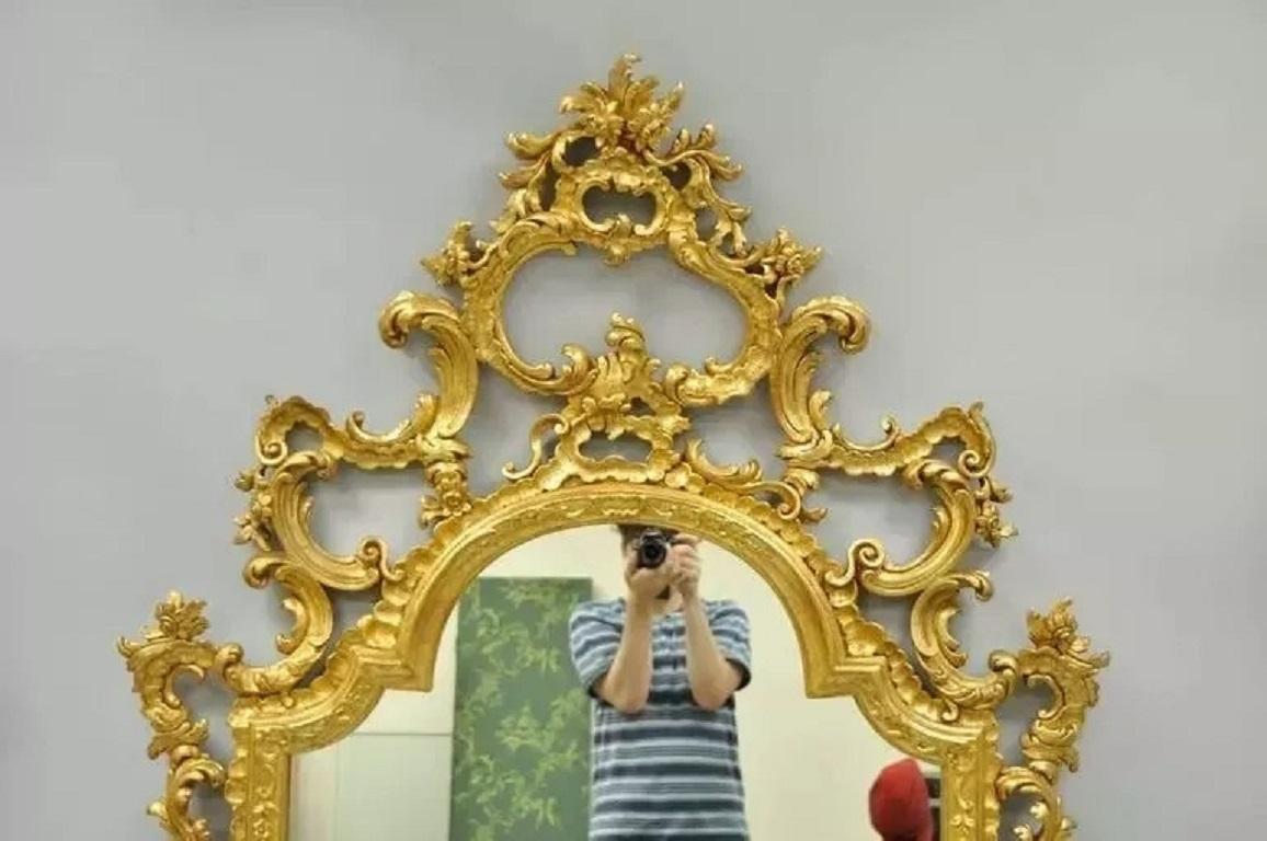 Labarge Gold Carved Giltwood French Louis XV Rococo Style Large Console Wall Mirror. Item features a substantial hand-carved wooden frame with ornate pierce carved floral scroll work and large arching pediment. A truly impressive work of art.