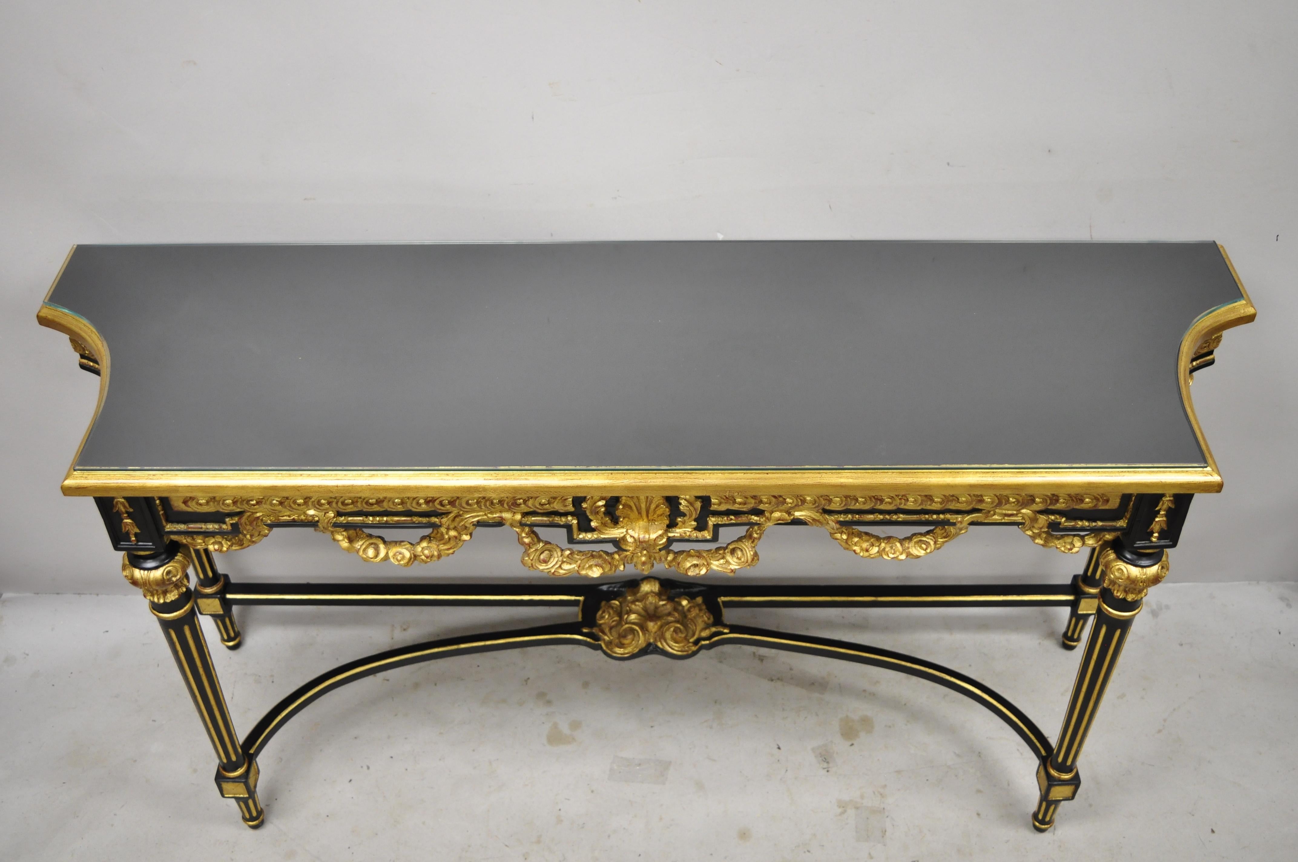 Table de salle console canapé de style Jansen en laque noire dorée de style Louis XVI. Cette pièce présente un plateau en verre, des détails dorés, une finition laquée noire, une construction en bois massif, des détails joliment sculptés, des pieds