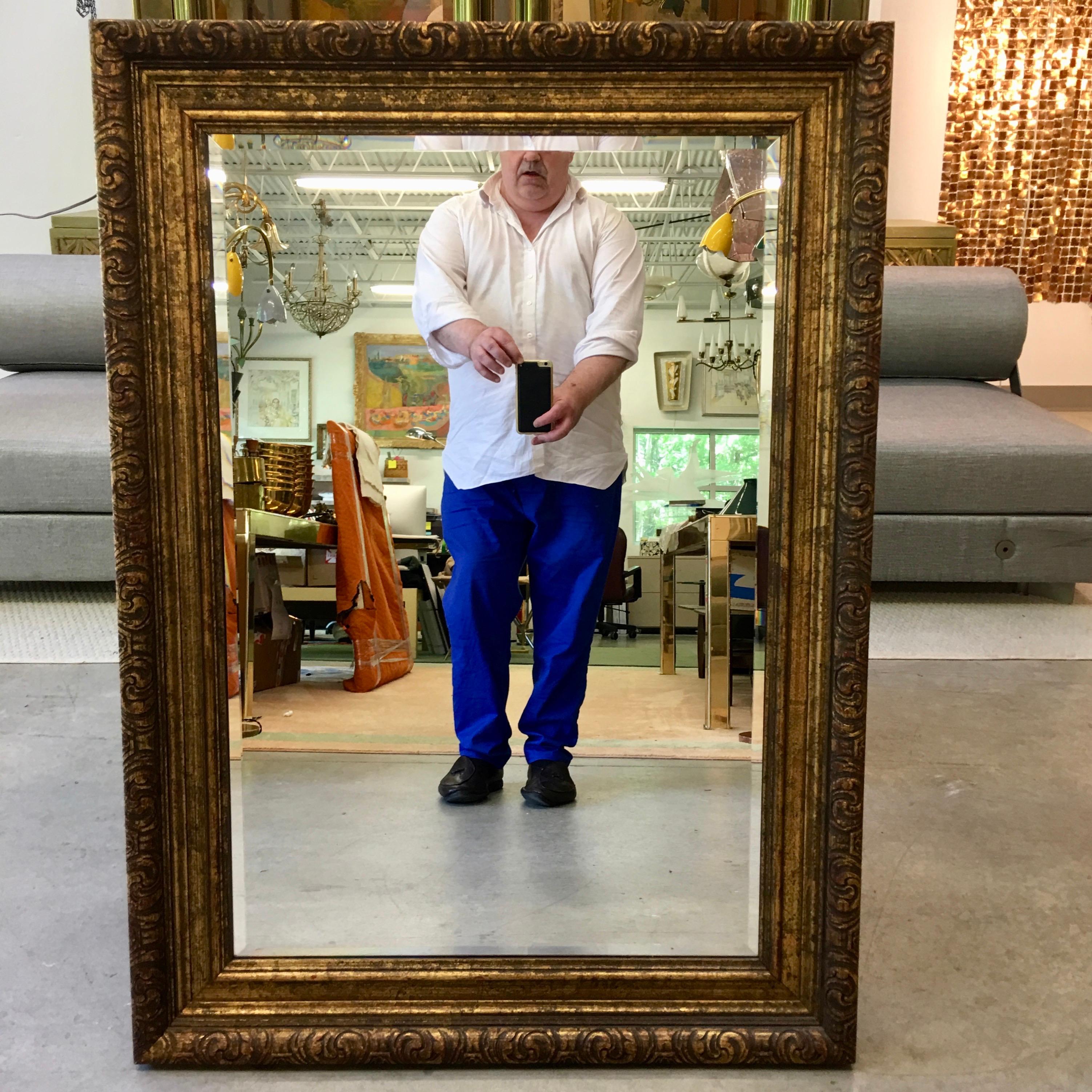 La Barge rectangular beveled mirror in carved giltwood frame. High quality from a trusted name. Circa 1960. Frame dimensions 43.5 inches high by 31.5 inches wide by 2 inches deep. Mirrored glass dimensions 35.5 inches high by 23.5 inches wide.