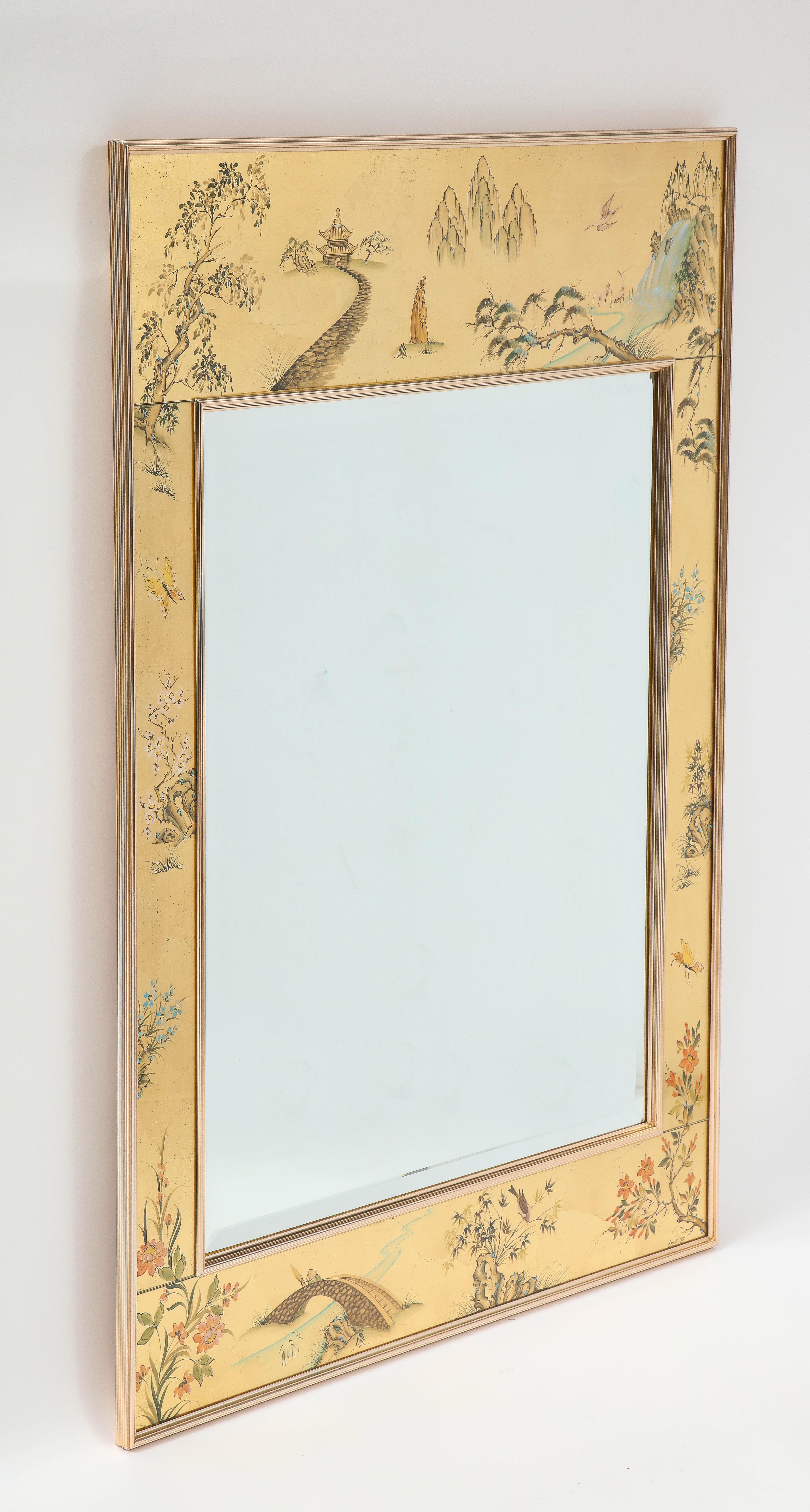 Mid-century mirror by La Barge featuring reverse gilded and hand painted glass depicting a Chinoiserie motif surrounds a glass mirror, framed in brass. Signed.