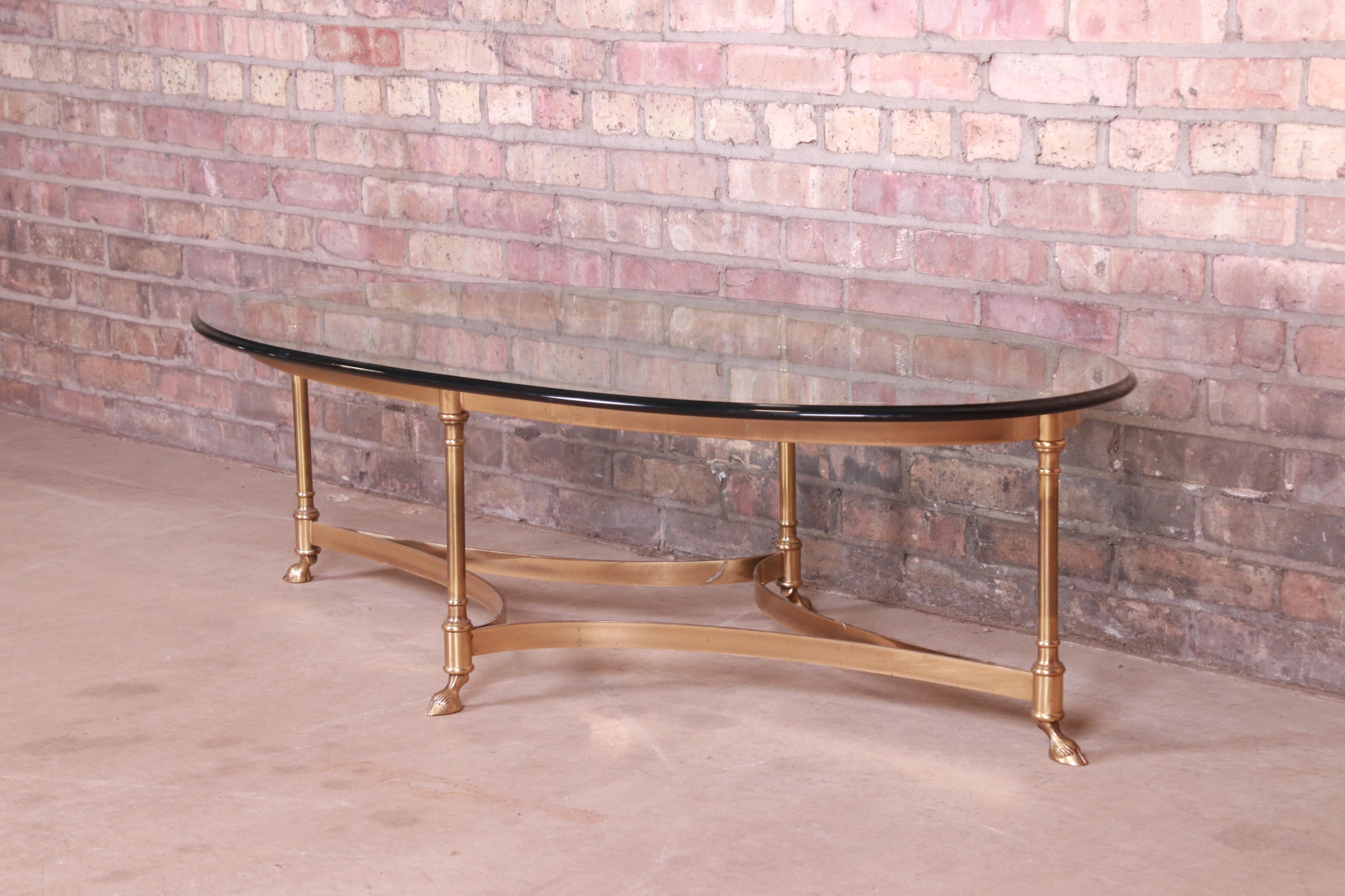 A gorgeous Mid-Century Modern Hollywood Regency brass and glass hooved feet coffee or cocktail table

By Labarge

Circa 1960s

Measures: 51.25