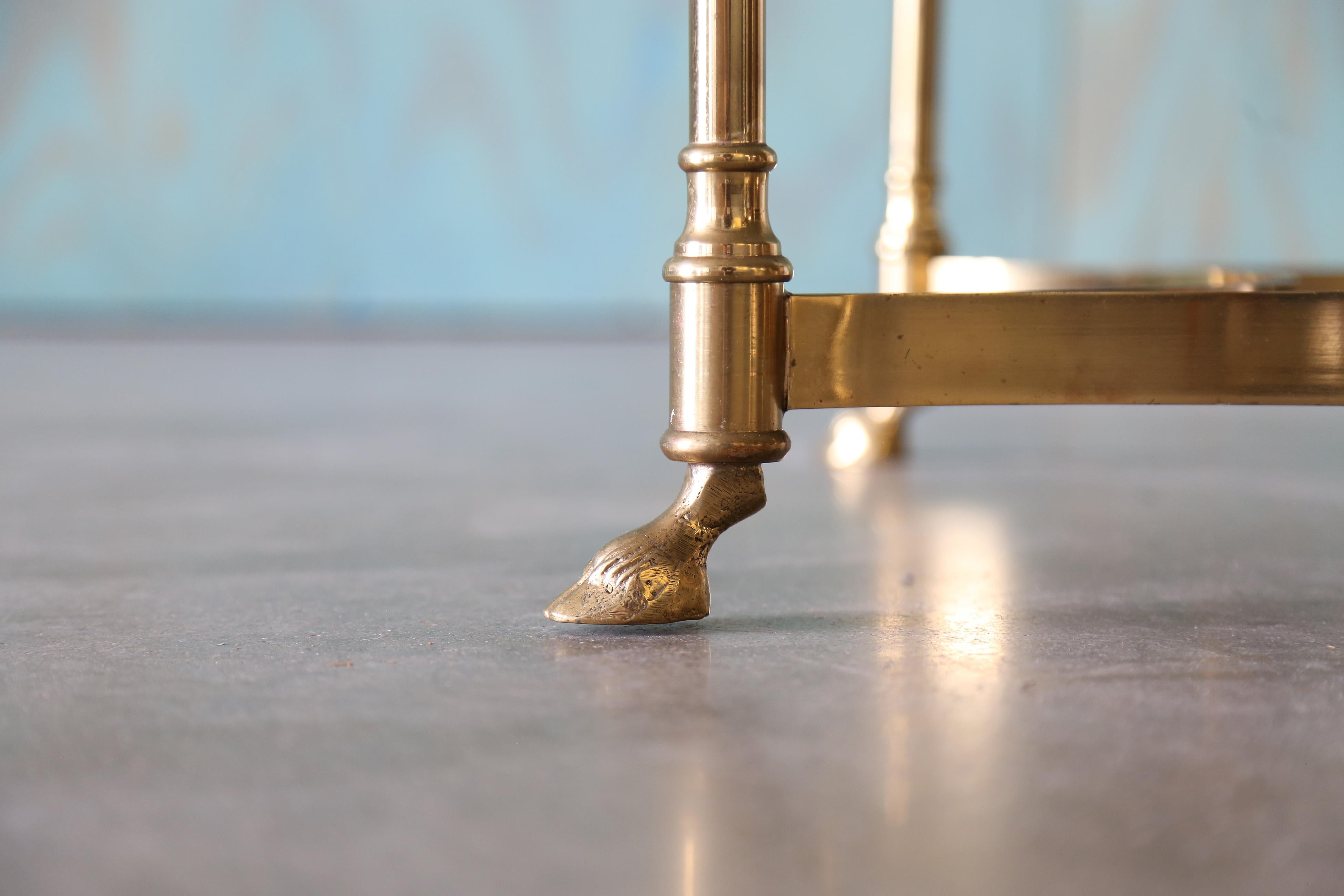 La reggenza hollywoodiana al suo meglio. Un tavolino o un tavolino occasionale in ottone e vetro in stile Labarge. Una base esagonale sostiene un piano esagonale con un'apertura appena sufficiente per offrire interesse e permettere all'ottone di