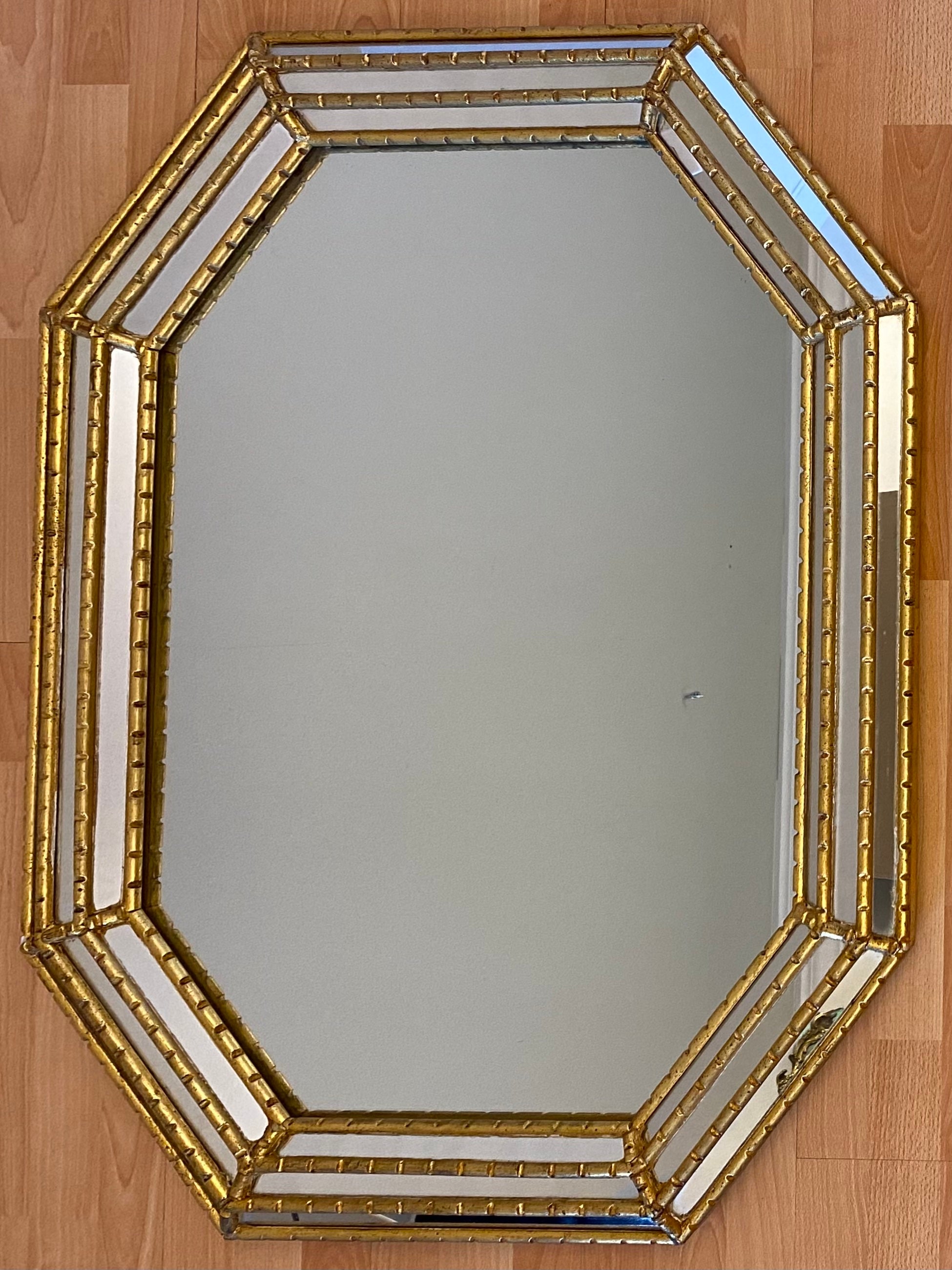 A fine quality octagonal gilt mirror featuring thick triple beveled edges and a wide frame. This is a beautiful and interesting shape, perfect for a hallway, entry above a console table or a vanity.

Solid wood and very well made piece. High end