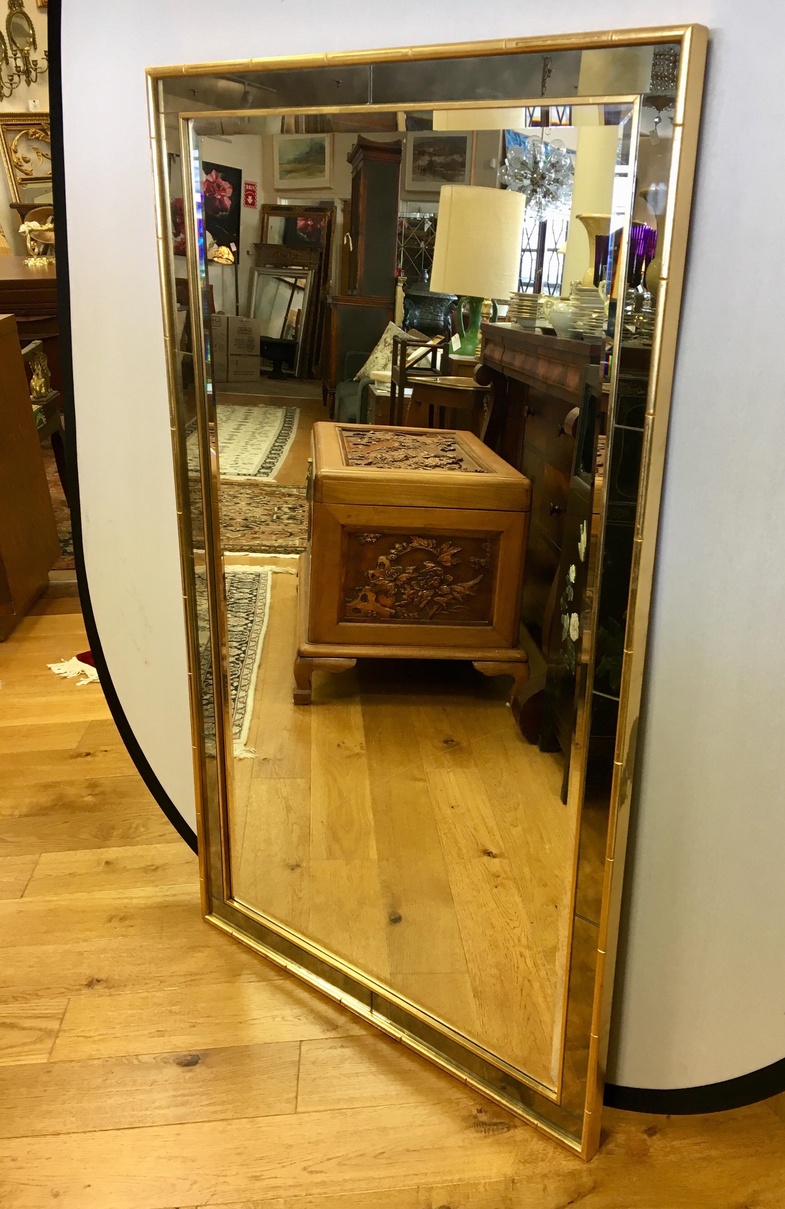 Rare and distinctive, this Labarge mirror has a gold faux bamboo frame with a bevelled mirror surrounded by a smoked mirrored mosaic border. It can be hung vertically or horizontally and is hallmarked in the back.