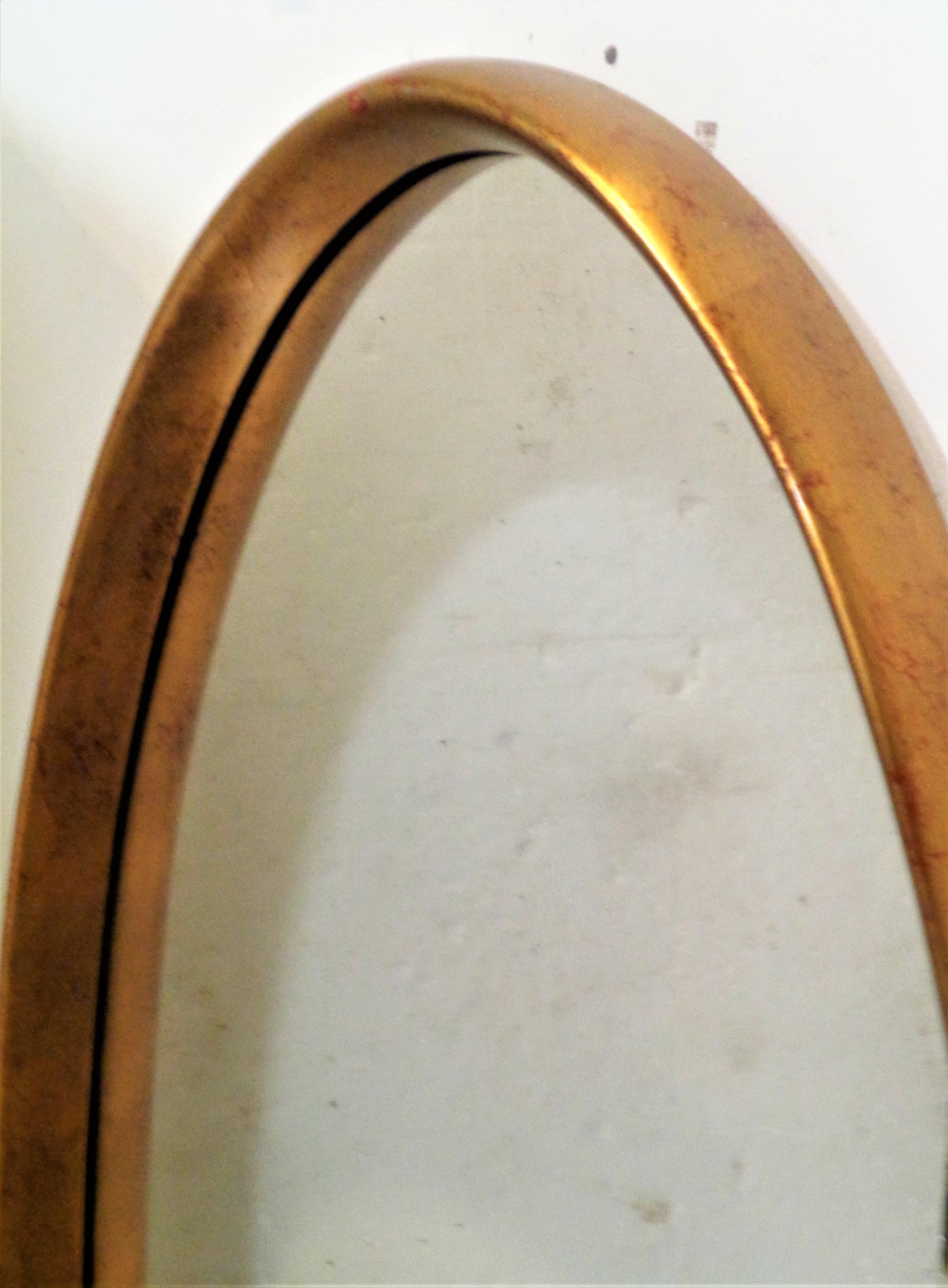 Beautiful elongated oval giltwood wall mirror by Labarge ( see label on reverse ) in all original glowing vintage condition. The gilding showing some underlying red bole. Circa 1960's. Look at all pictures and read condition report in comment