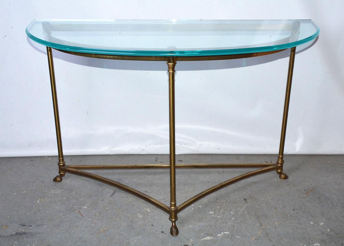 French mid-century brass three legged demi lune console table with hoof feet and glass top attributed to La Barge. Original condition with natural patina on base and some surface scratching to glass top.
Measures: Table base D 15.13