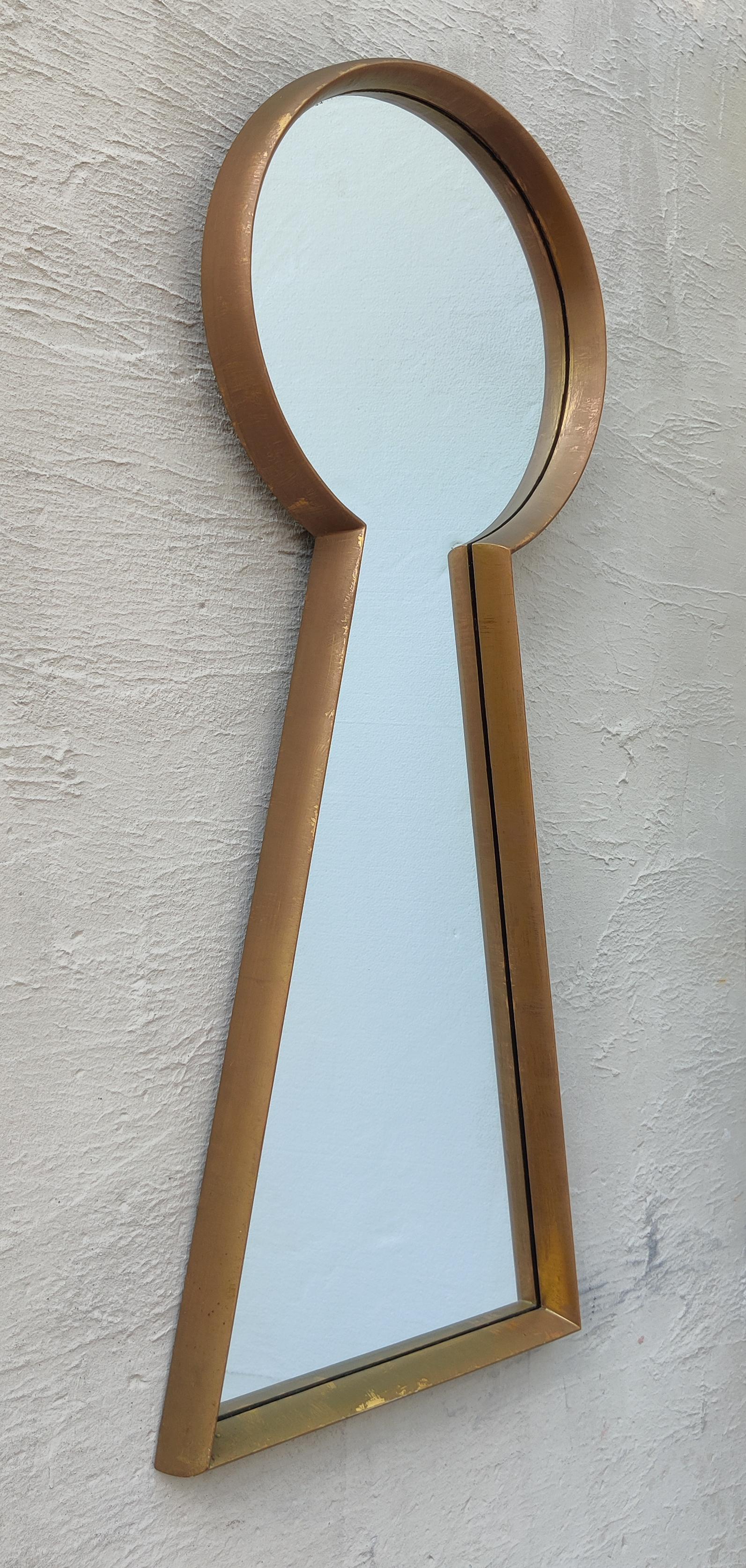 In the style of manufacturer LaBarge, this large mirror features a well-proportioned keyhole shape with a carved and gilt wooden frame. A handsome accent piece for any modern home or hallway. Dated 1962. 

In good vintage and original condition. No