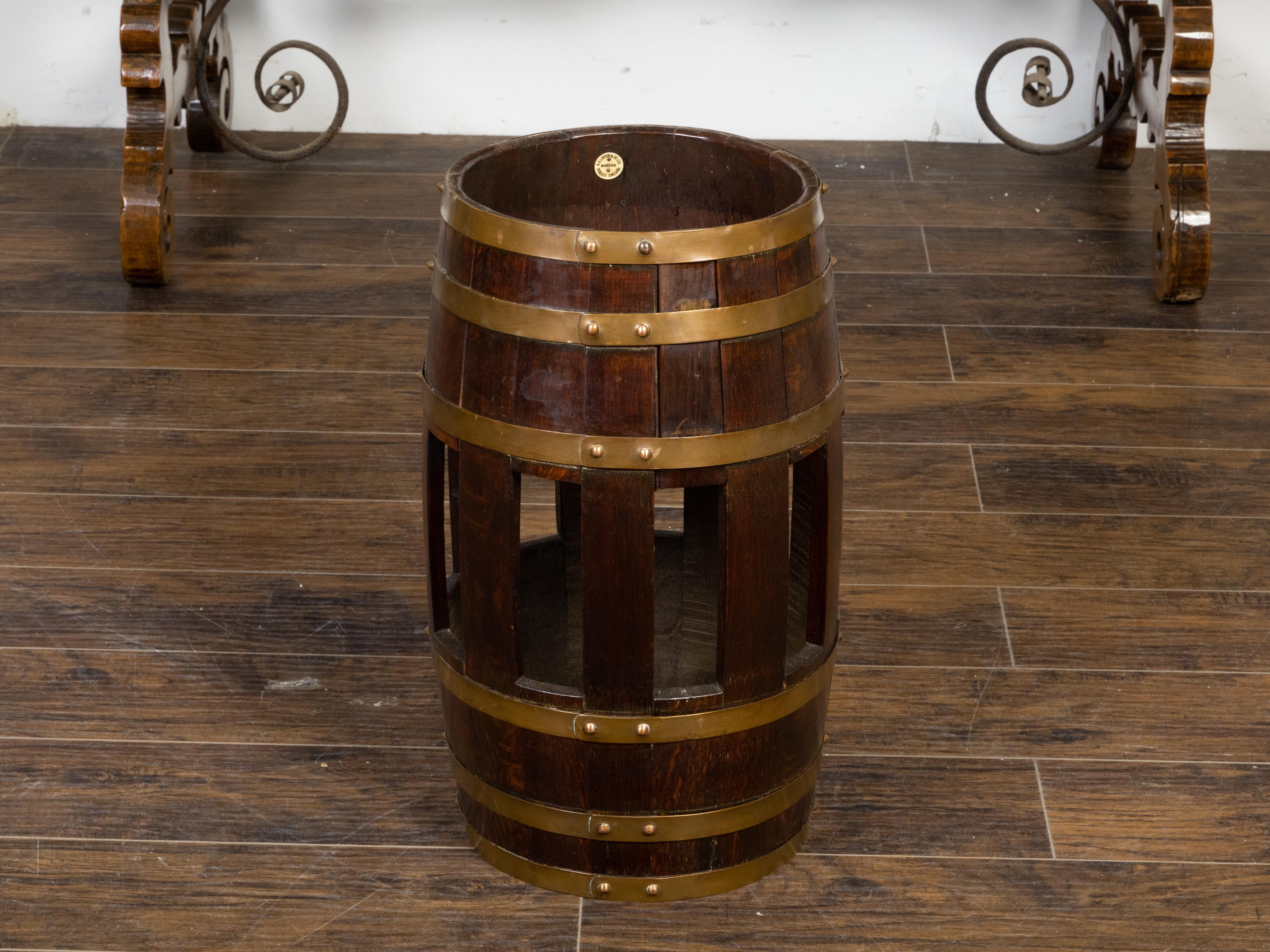 A rustic English turn of the century oak barrel from the early 20th century with six brass braces and open accents, made and labeled by R.A. Lister & Co. Dursley, England. Created in England during the Turn of the Century which saw the transition