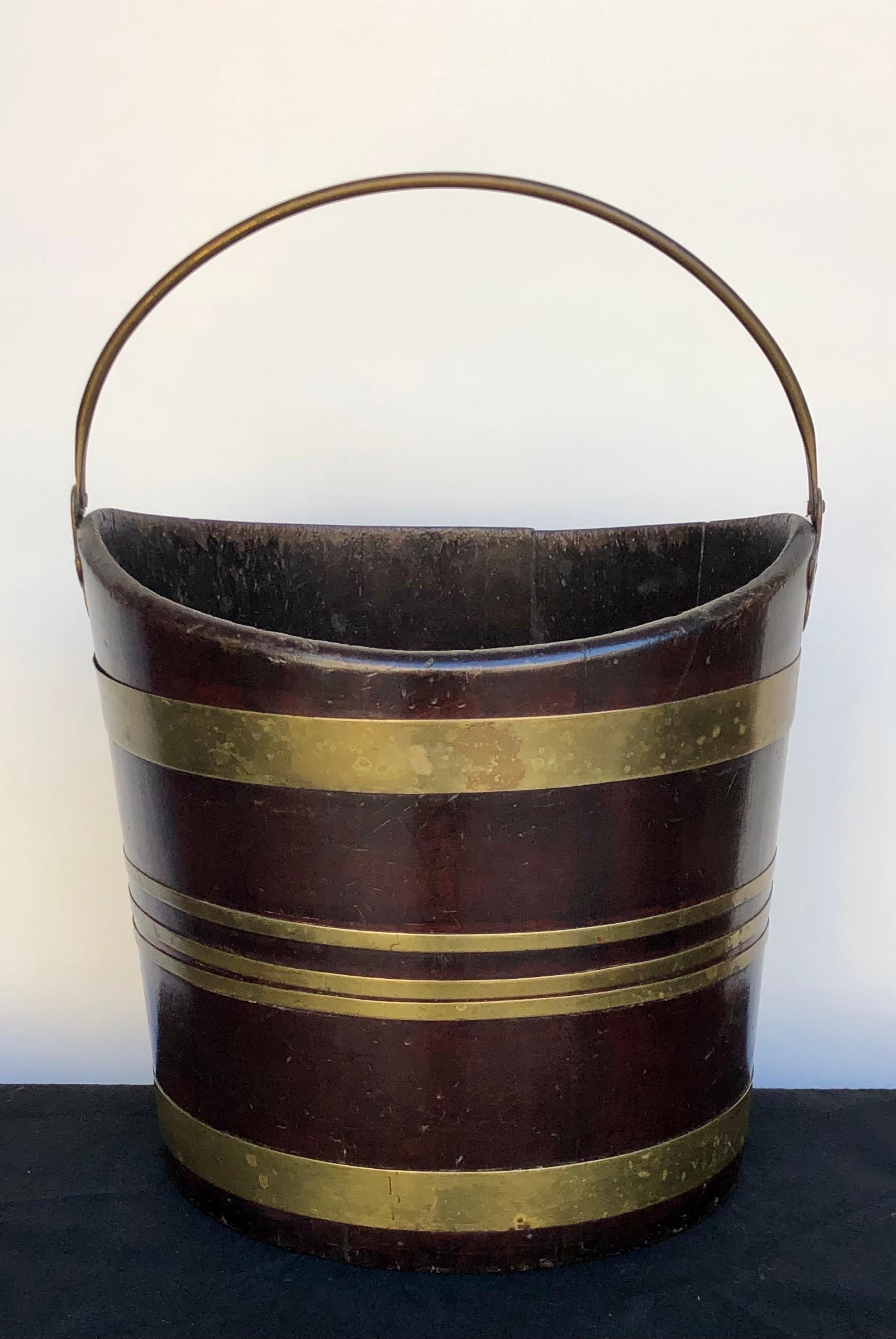 This wonderful Labeled Regency brass-bound mahogany navette form peat bucket / fire bucket was made in England in the early 19th century. The Navette Form peat bucket is handmade with coopered mahogany staves and bound together in brass bands with