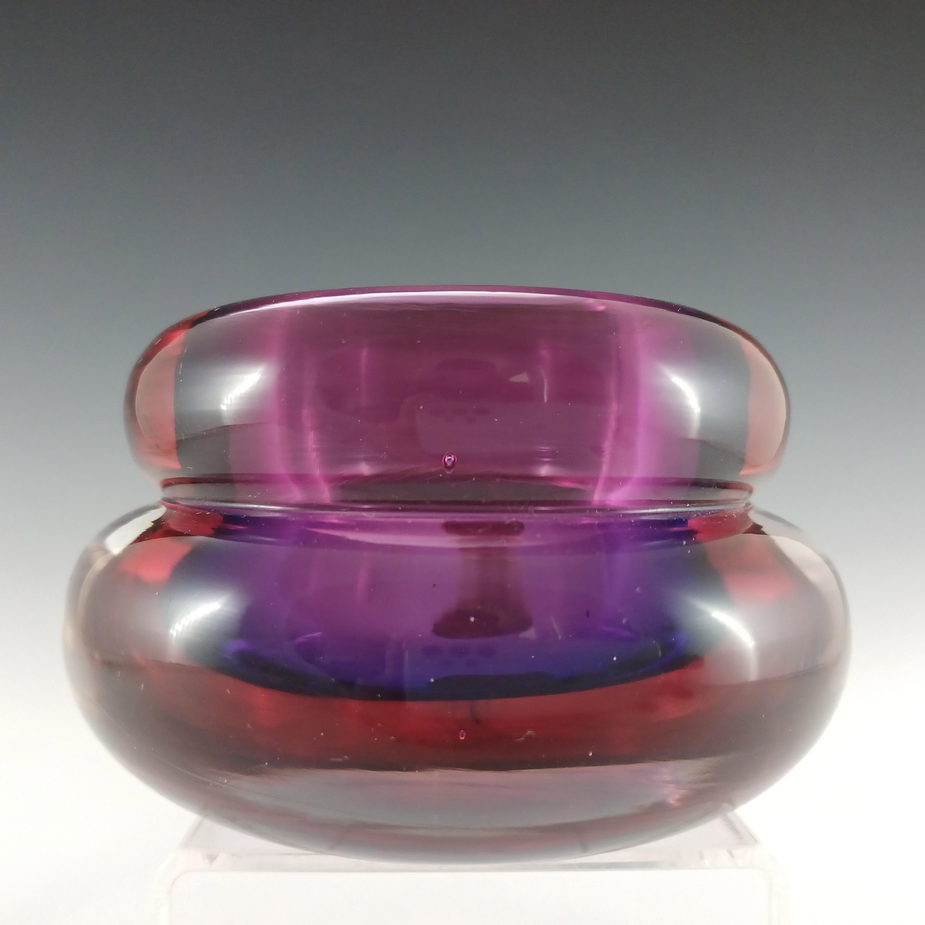 Se trata de un magnífico portavelas de cristal veneciano de los años 50/60, fabricado en la isla de Murano, cerca de Venecia, Italia. En una asombrosa combinación de cristal morado revestido de cristal rosa, que a su vez está revestido de cristal