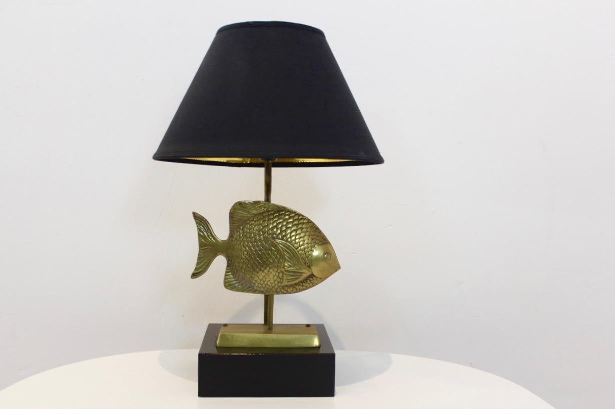 Exclusive, unique and exotic brass table lamp with a fish sculpture, produced by Deknudt Belgium in the 1970s. The lamp comes with the Original label from ‘Lustrerie Deknudt’. It comes also with the original shade and a solid black wooden base and