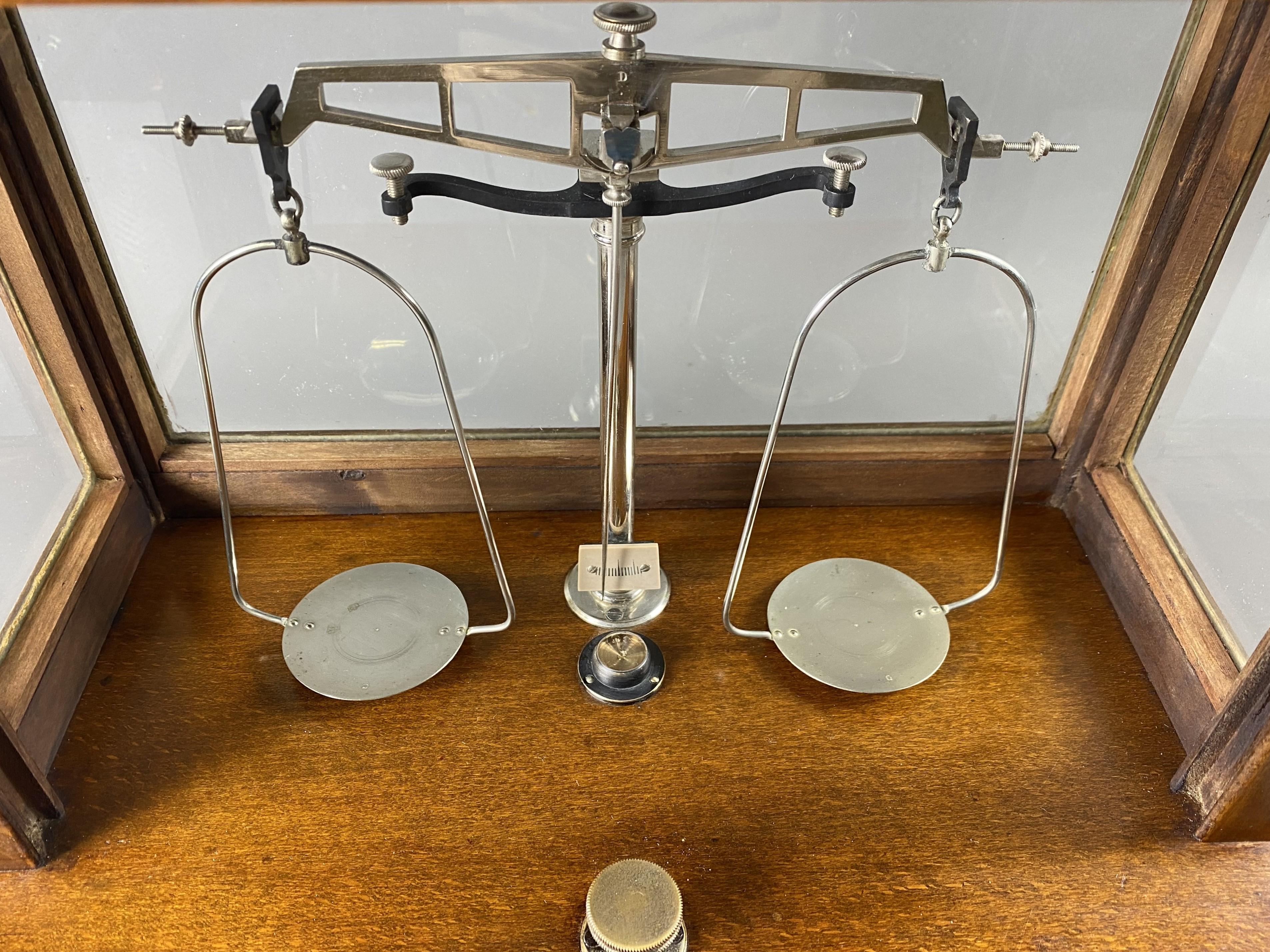 Pharmacy/laboratory trebuchet scale in its all-sided glass case, a vertical sliding door on the front, a storage drawer at the bottom.

Complete with its original accessories, functional.

Mabille House in Paris.

Very good condition