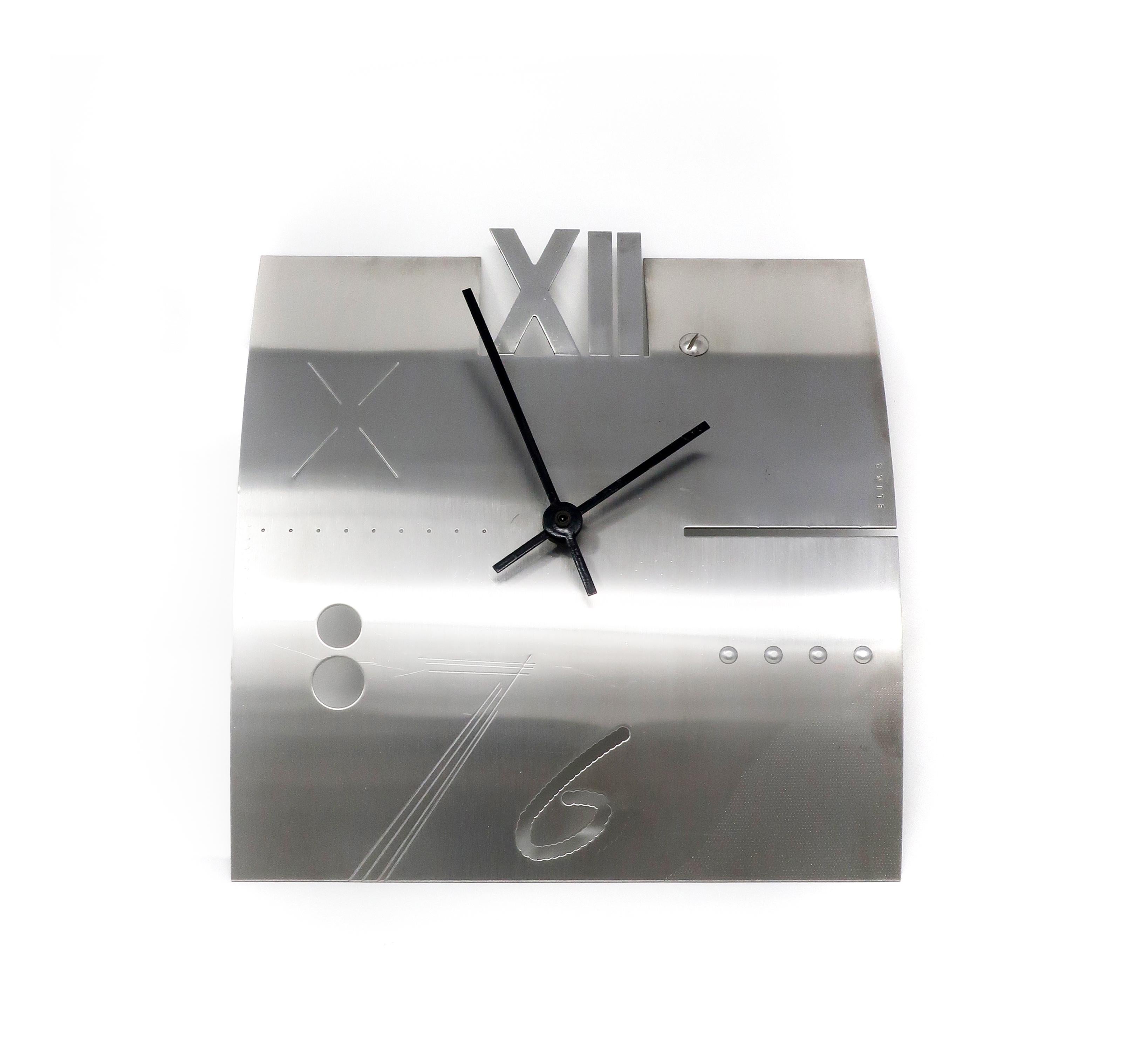 A Postmodern stainless steel wall clock designed by Constantin Boym for Elika (1989). Named “Laborious” because it uses many fabrication processes to create the clock face: perforating, stamping, etching, and screwing into the surface. 

In