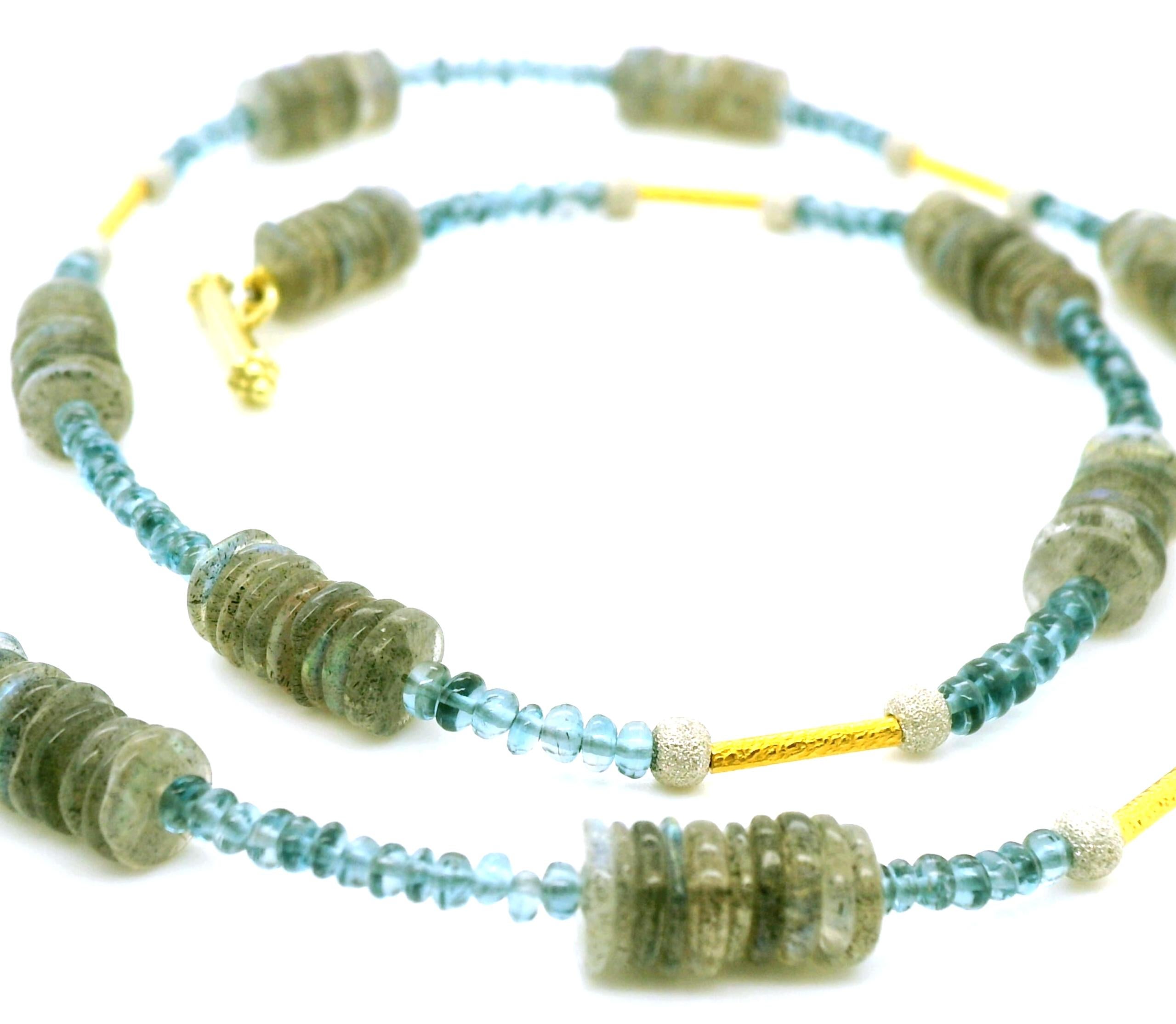 This colorful necklace features beautifully speckled labradorite disc beads arranged with rich, transparent blue topaz beads and gold accents in an eye-catching strand that can easily be dressed up or down. The warmly hued labradorite beads vary